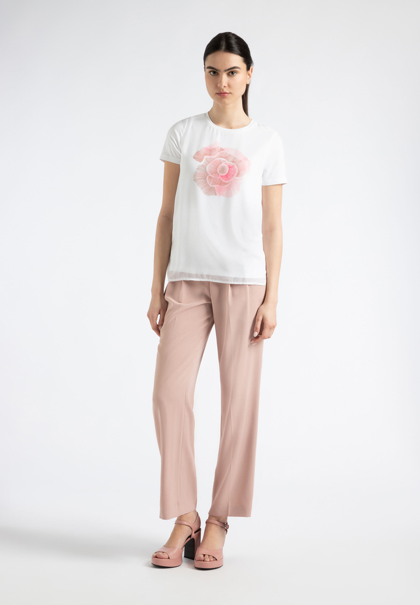 Eine Frau, die eine MORE & MORE Hose und ein T-Shirt mit Blumenmotiv trägt. Eine Frau, die eine MORE & MORE Hose und ein T-Shirt mit Blumenmotiv trägt.