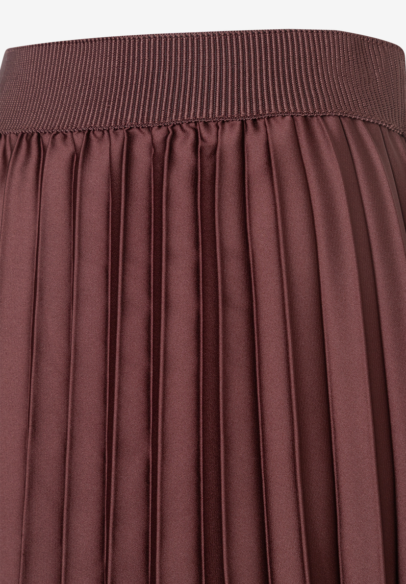 Nahaufnahme eines dunkelbraunen Faltenrocks von MORE & MORE mit elastischem Bund und fließender Polyester-Materialkonstruktion. Nahaufnahme eines dunkelbraunen Faltenrocks von MORE & MORE mit elastischem Bund und fließender Polyester-Materialkonstruktion.