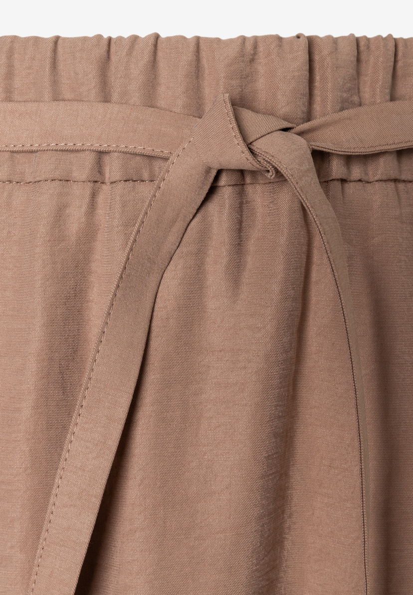 Nahaufnahme eines MORE & MORE Rocks mit fließender Webware und Bindeband. Nahaufnahme eines MORE & MORE Rocks mit fließender Webware und Bindeband.