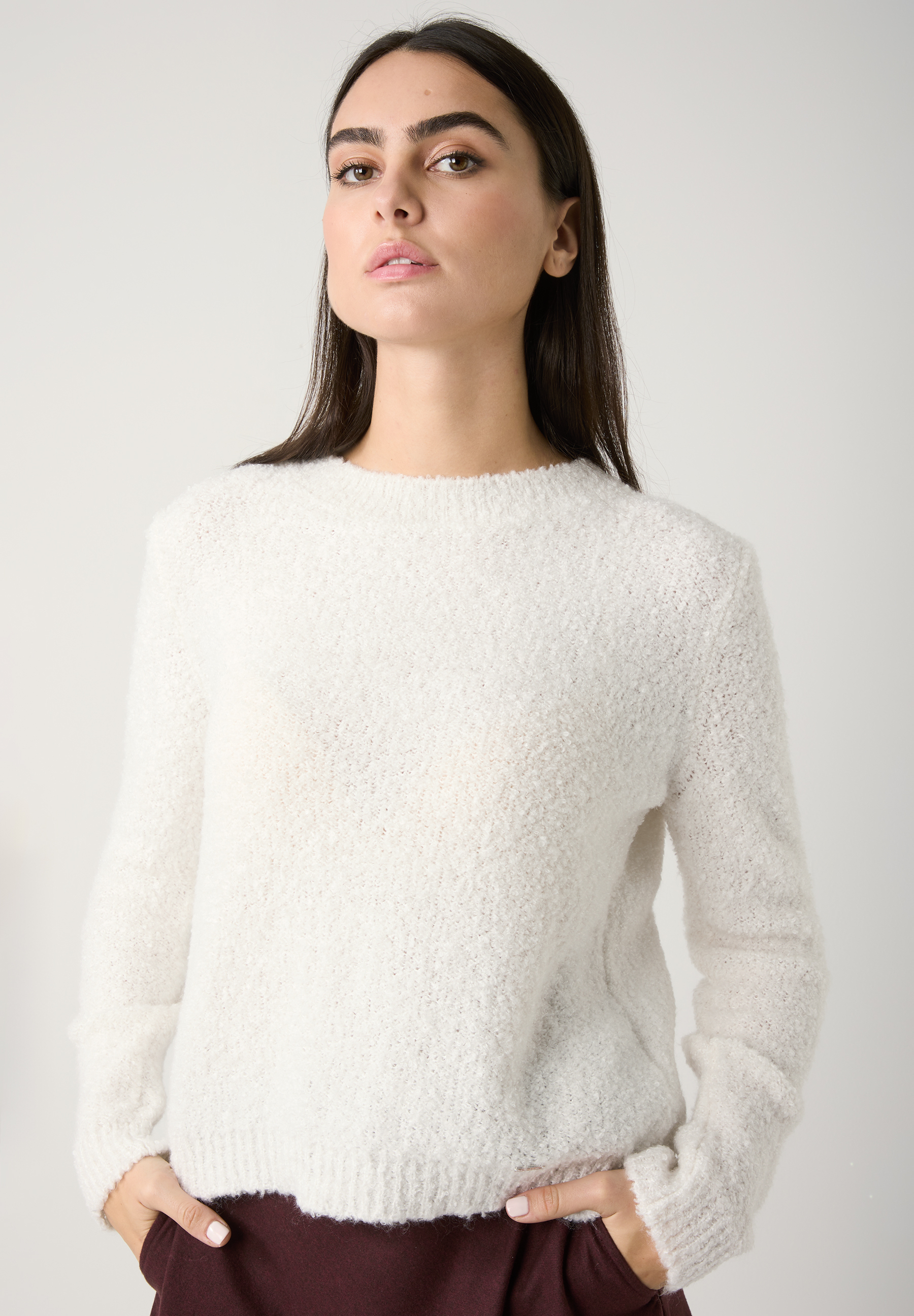 Eine Frau mit MORE & MORE Bouclé-Pullover, Strick, wärmend und angenehm zu tragen.