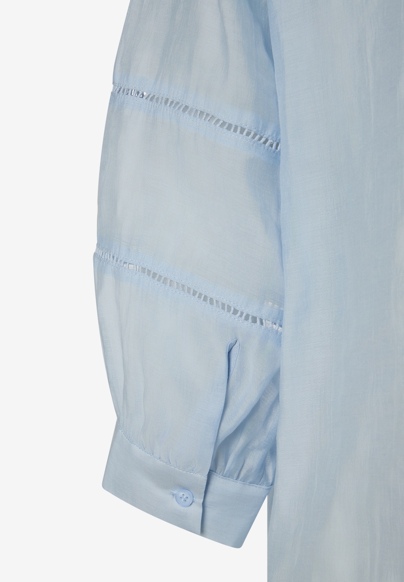 Detailaufnahme einer hellblauen MORE & MORE Bluse mit Lochmuster am Ärmel. Detailaufnahme einer hellblauen MORE & MORE Bluse mit Lochmuster am Ärmel.