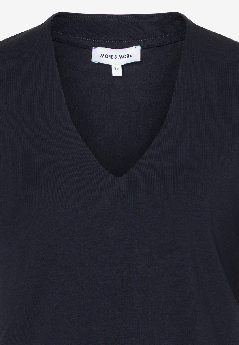 Nahaufnahme eines marineblauen MORE & MORE T-Shirts mit V-Ausschnitt aus Jersey-Material. Nahaufnahme eines marineblauen MORE & MORE T-Shirts mit V-Ausschnitt aus Jersey-Material.