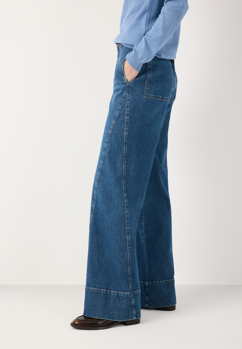MORE & MORE Jeans: Weit geschnittene, dunkelblaue Jeans mit Taschen und doppelter Manschette, kombiniert mit blauem Oberteil