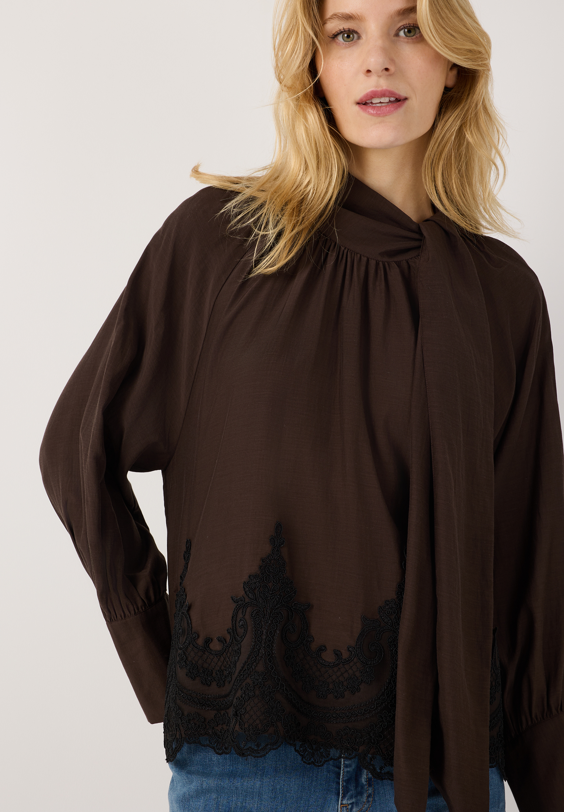 MORE & MORE Bluse: Eine elegante, braune MORE & MORE Bluse mit einem hohen Halsausschnitt und schwarzer Spitze.