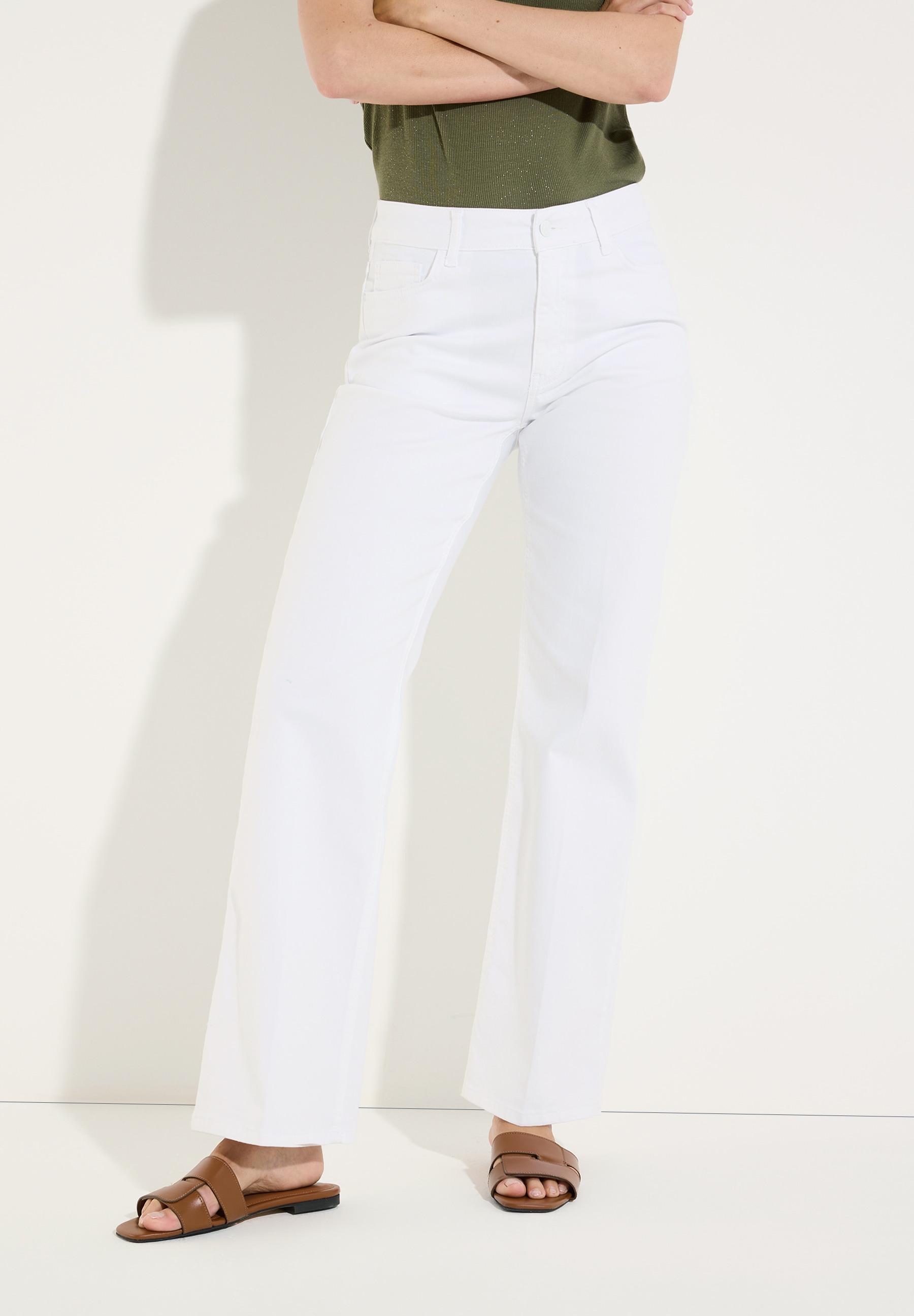 MORE & MORE Jeans: Weiße Jeans in geradem Schnitt, kombiniert mit dunkelgrünem Oberteil und braunen Sandalen.