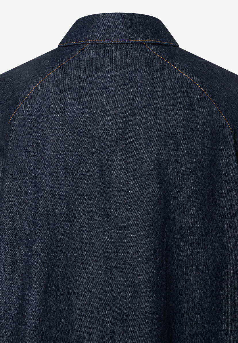 Nahaufnahme der Rückseite einer MORE & MORE Bluse aus dunklem Jeansstoff mit Kragen und gelben Nähten. Nahaufnahme der Rückseite einer MORE & MORE Bluse aus dunklem Jeansstoff mit Kragen und gelben Nähten.