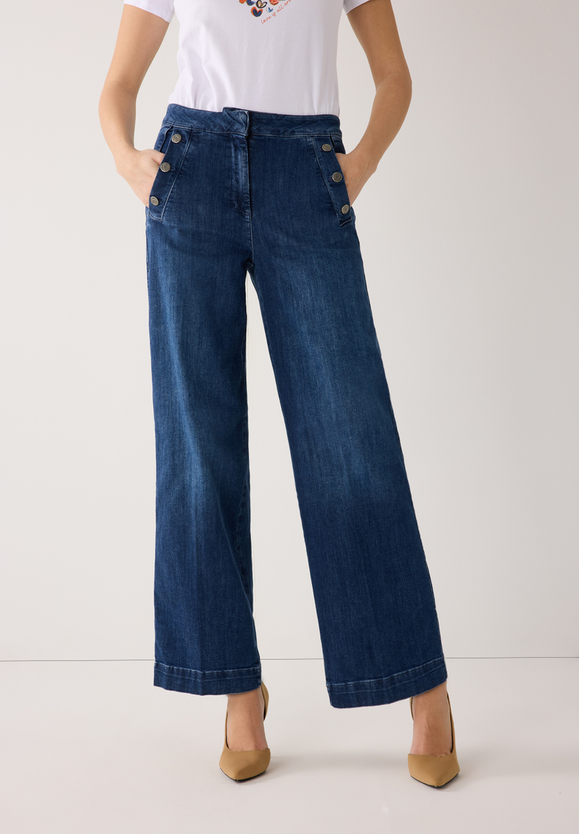 Eine Frau mit MORE & MORE Jeanshose aus Denim. Die Hose ist weit geschnitten und hat Knöpfe an der Taille. Eine Frau mit MORE & MORE Jeanshose aus Denim. Die Hose ist weit geschnitten und hat Knöpfe an der Taille.