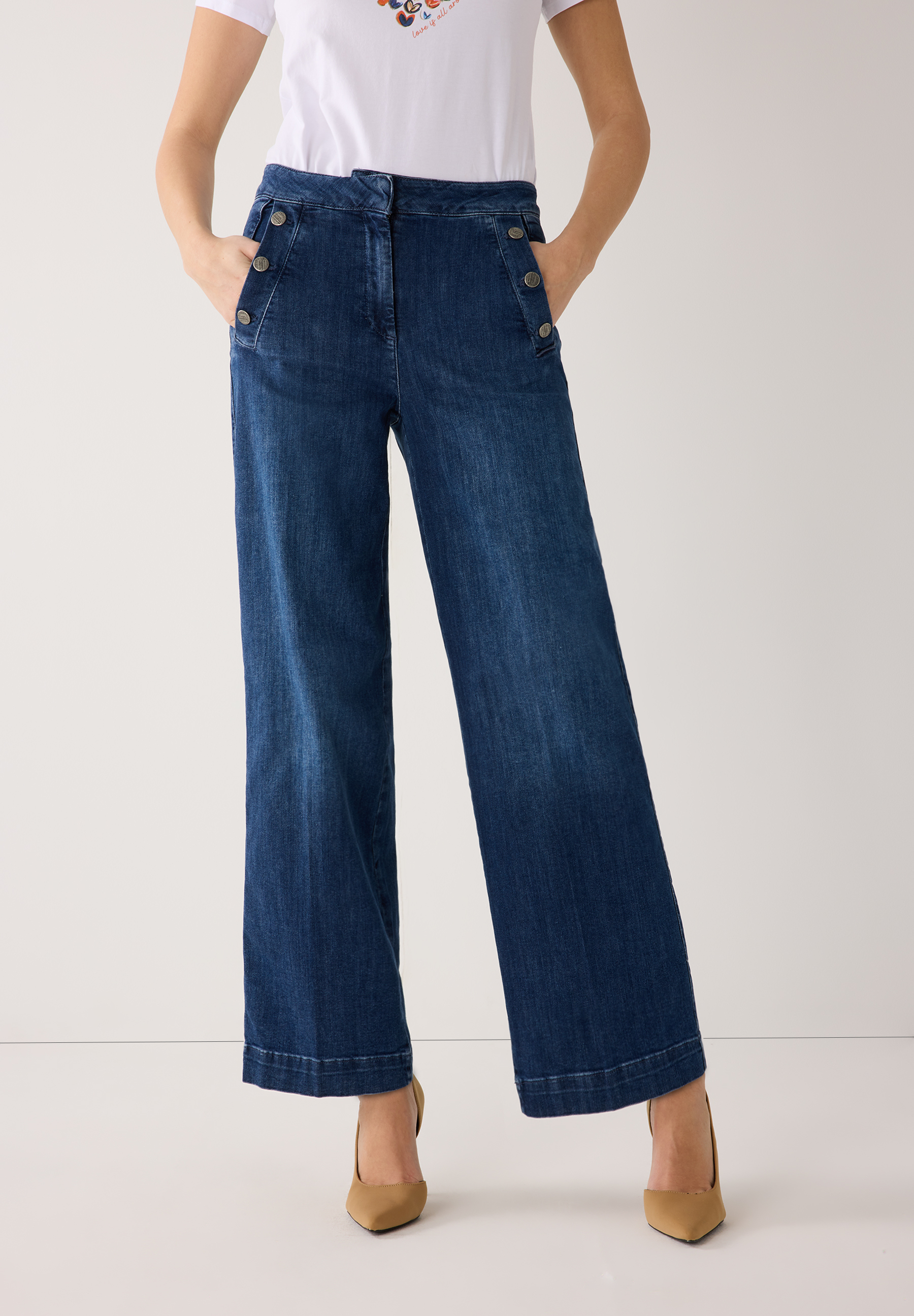 Eine Frau mit MORE & MORE Jeanshose aus Denim. Die Hose ist weit geschnitten und hat Knöpfe an der Taille.