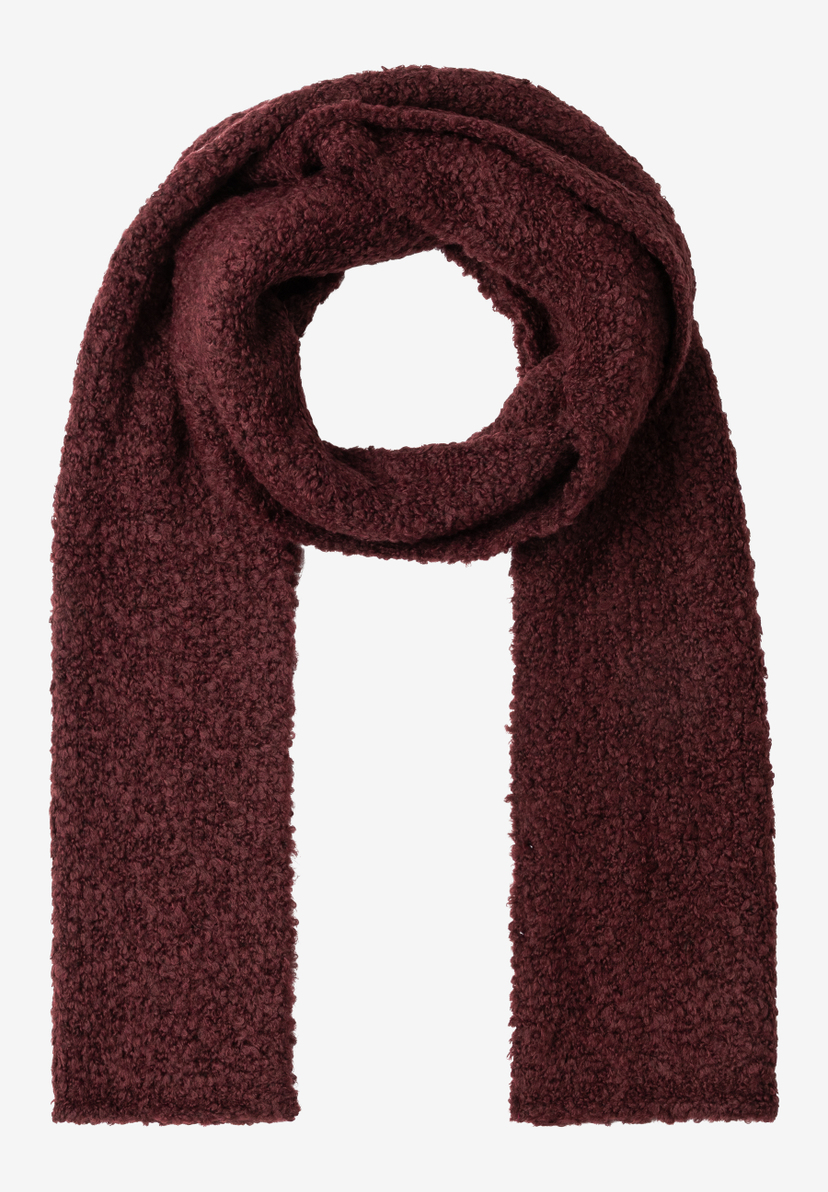 Ein bordeauxroter, grob gestrickter MORE & MORE Schal liegt geworfen, um eine Schlaufe zu bilden. Ein bordeauxroter, grob gestrickter MORE & MORE Schal liegt geworfen, um eine Schlaufe zu bilden.
