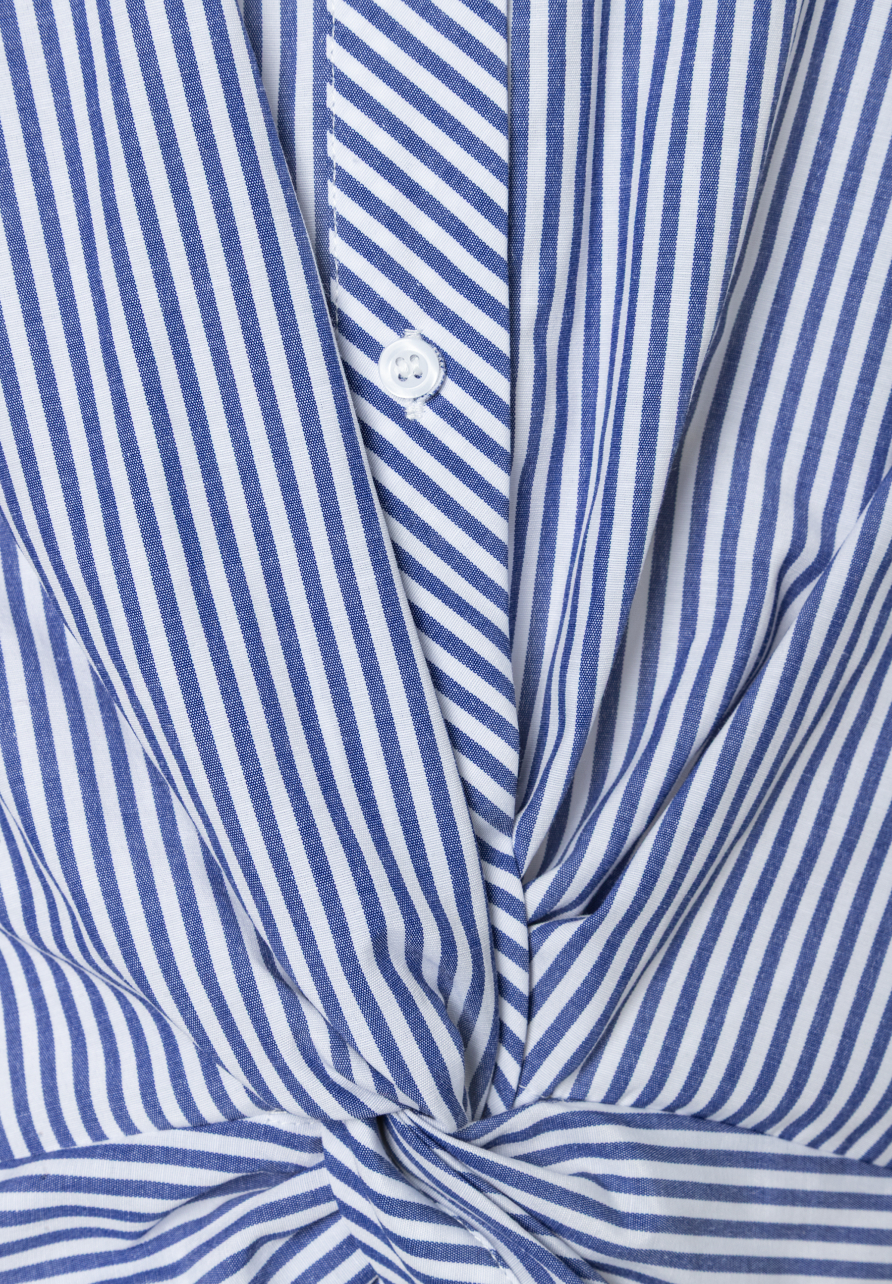 Nahaufnahme einer blau-weiß gestreiften Bluse von MORE & MORE aus Popeline mit Knopf und Knotendetail. Nahaufnahme einer blau-weiß gestreiften Bluse von MORE & MORE aus Popeline mit Knopf und Knotendetail.