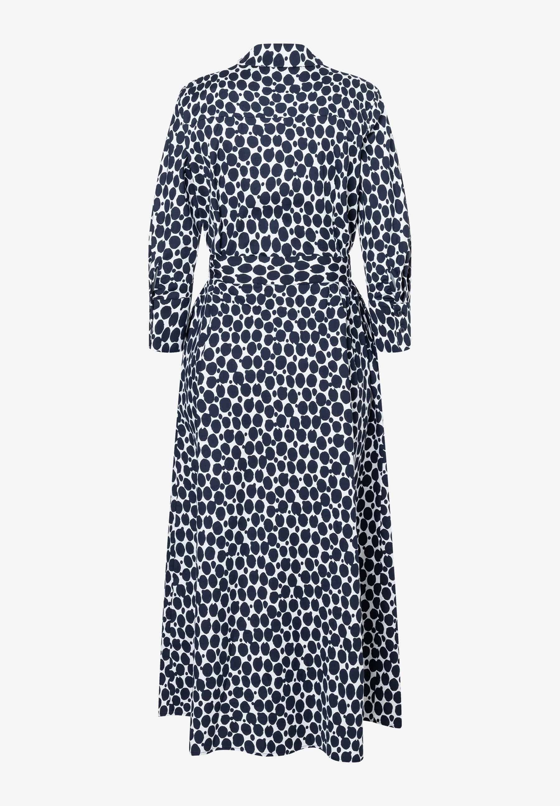 Ein MORE & MORE Kleid mit einem Muster aus dunkelblauen Punkten auf weißem Grund, von hinten fotografiert. Ein MORE & MORE Kleid mit einem Muster aus dunkelblauen Punkten auf weißem Grund, von hinten fotografiert.