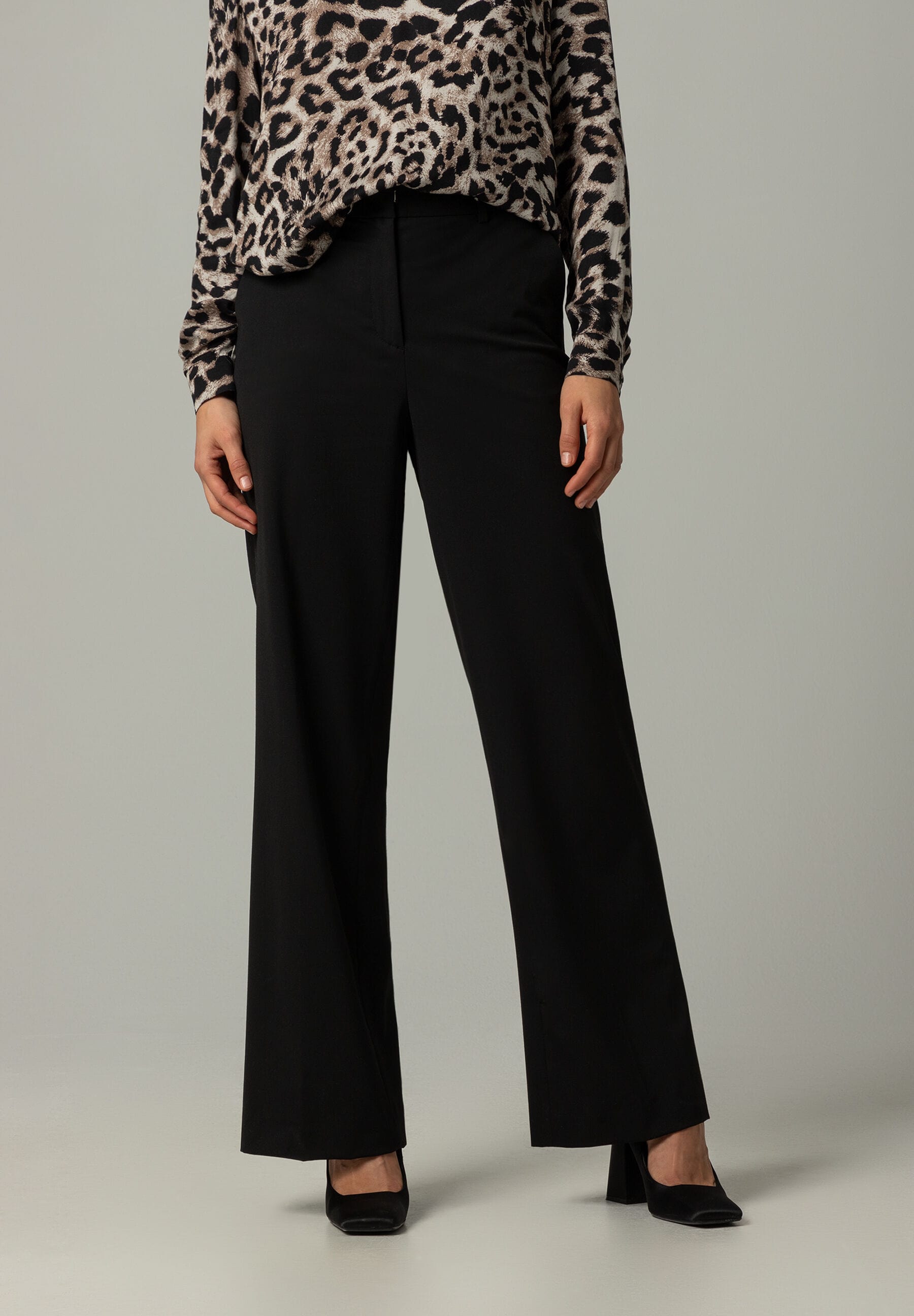 Eine MORE & MORE Hose aus Gabardine-Stretch in Schwarz, kombiniert mit einer Bluse mit Tiermuster. Eine MORE & MORE Hose aus Gabardine-Stretch in Schwarz, kombiniert mit einer Bluse mit Tiermuster.