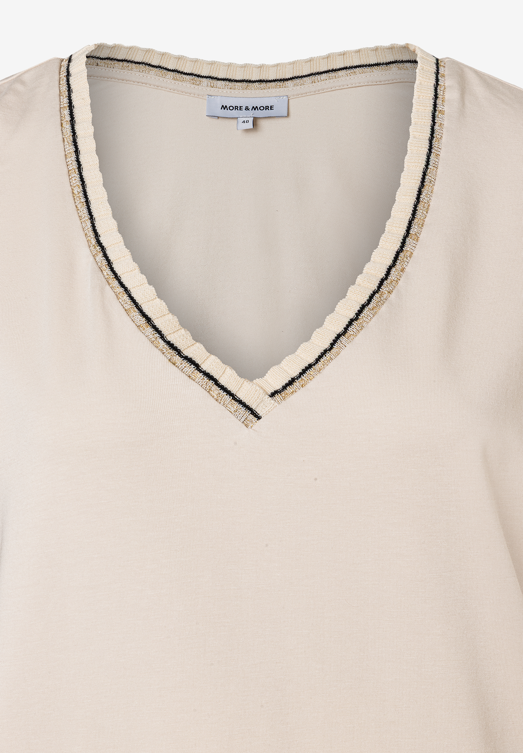 Nahaufnahme eines MORE & MORE Oberteils aus Jersey mit V-Ausschnitt und Zierstreifen. Nahaufnahme eines MORE & MORE Oberteils aus Jersey mit V-Ausschnitt und Zierstreifen.