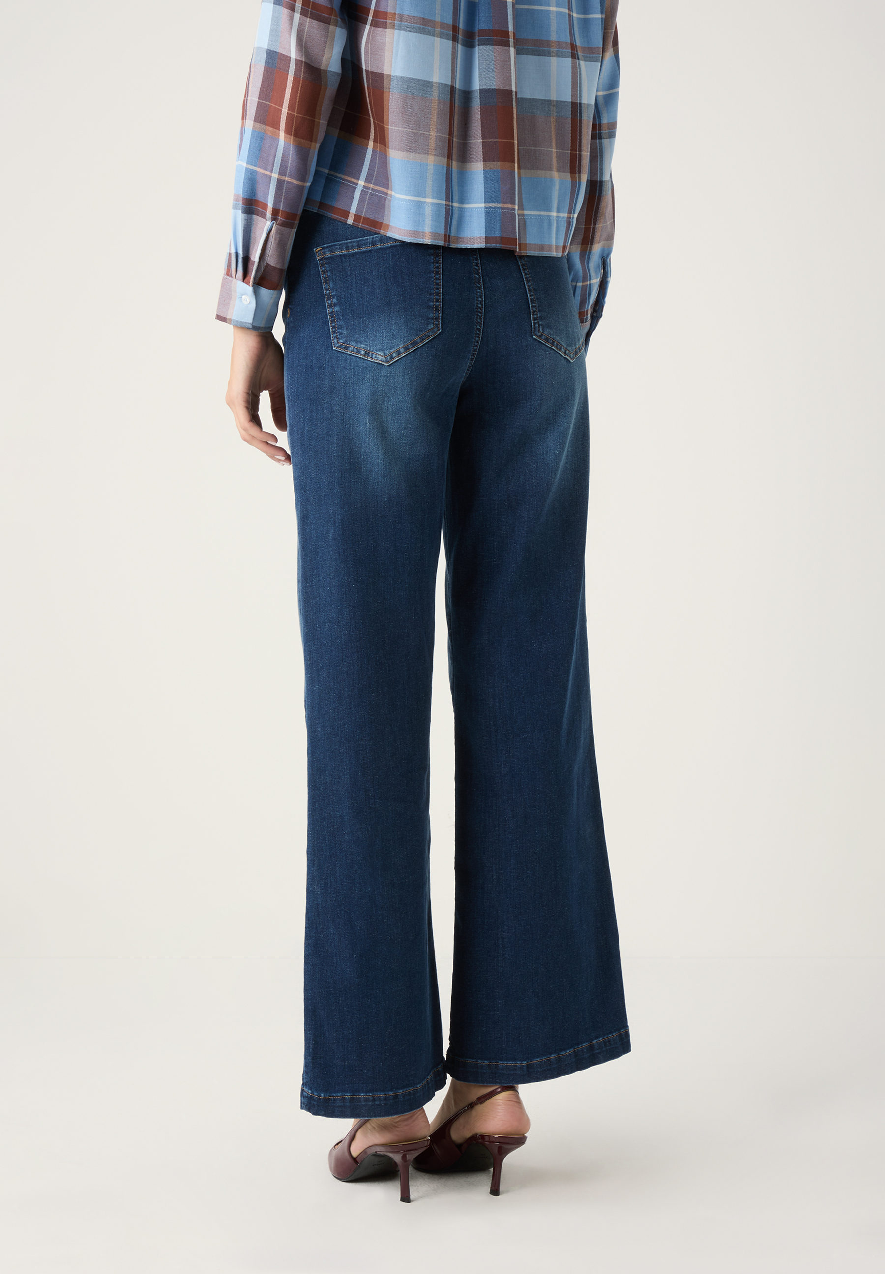 Eine MORE & MORE Denim-Hose mit weitem Bein und bequemen Tragekomfort, abgebildet von hinten. Eine MORE & MORE Denim-Hose mit weitem Bein und bequemen Tragekomfort, abgebildet von hinten.