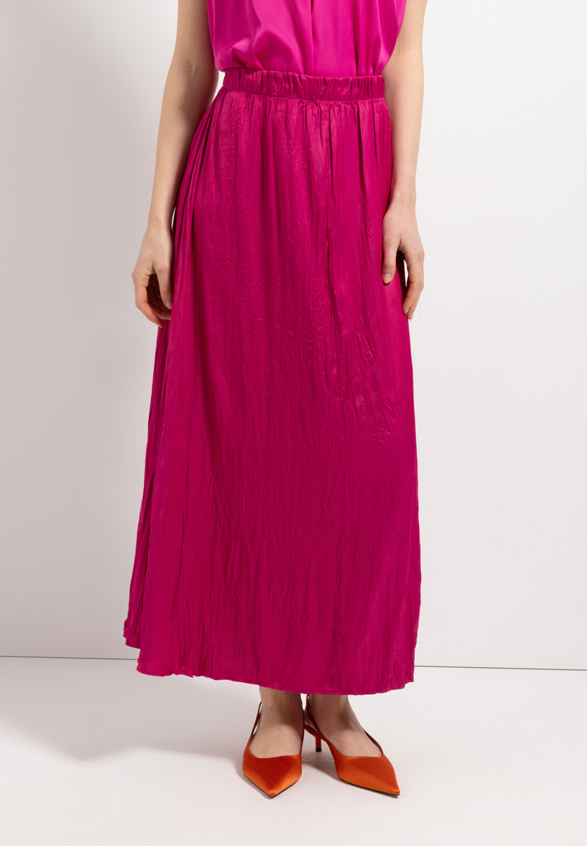 Eine Frau trägt eine lange, pinke MORE & MORE Hose und orangefarbene Schuhe vor einem weißen Hintergrund. Eine Frau trägt eine lange, pinke MORE & MORE Hose und orangefarbene Schuhe vor einem weißen Hintergrund.