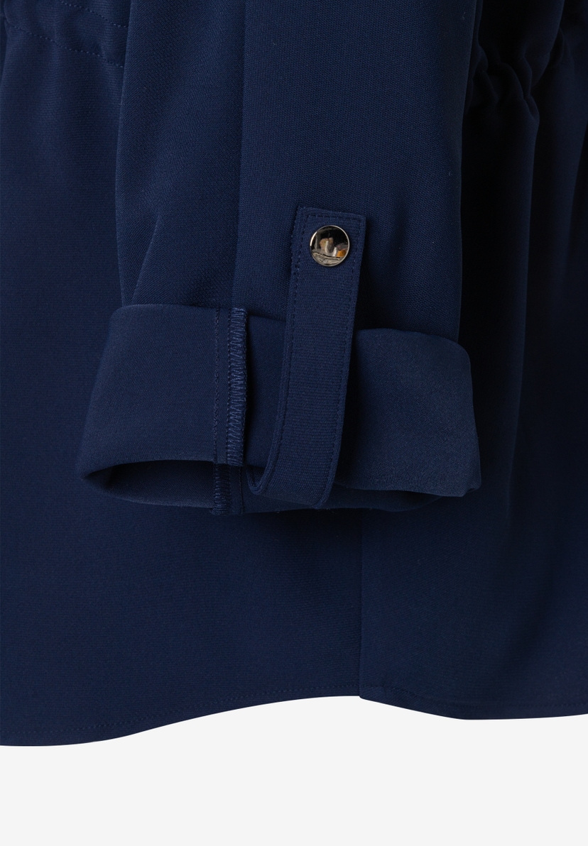 Nahaufnahme einer marineblauen MORE & MORE Bluse aus Webware mit Manschette und Knopfdetail. Nahaufnahme einer marineblauen MORE & MORE Bluse aus Webware mit Manschette und Knopfdetail.