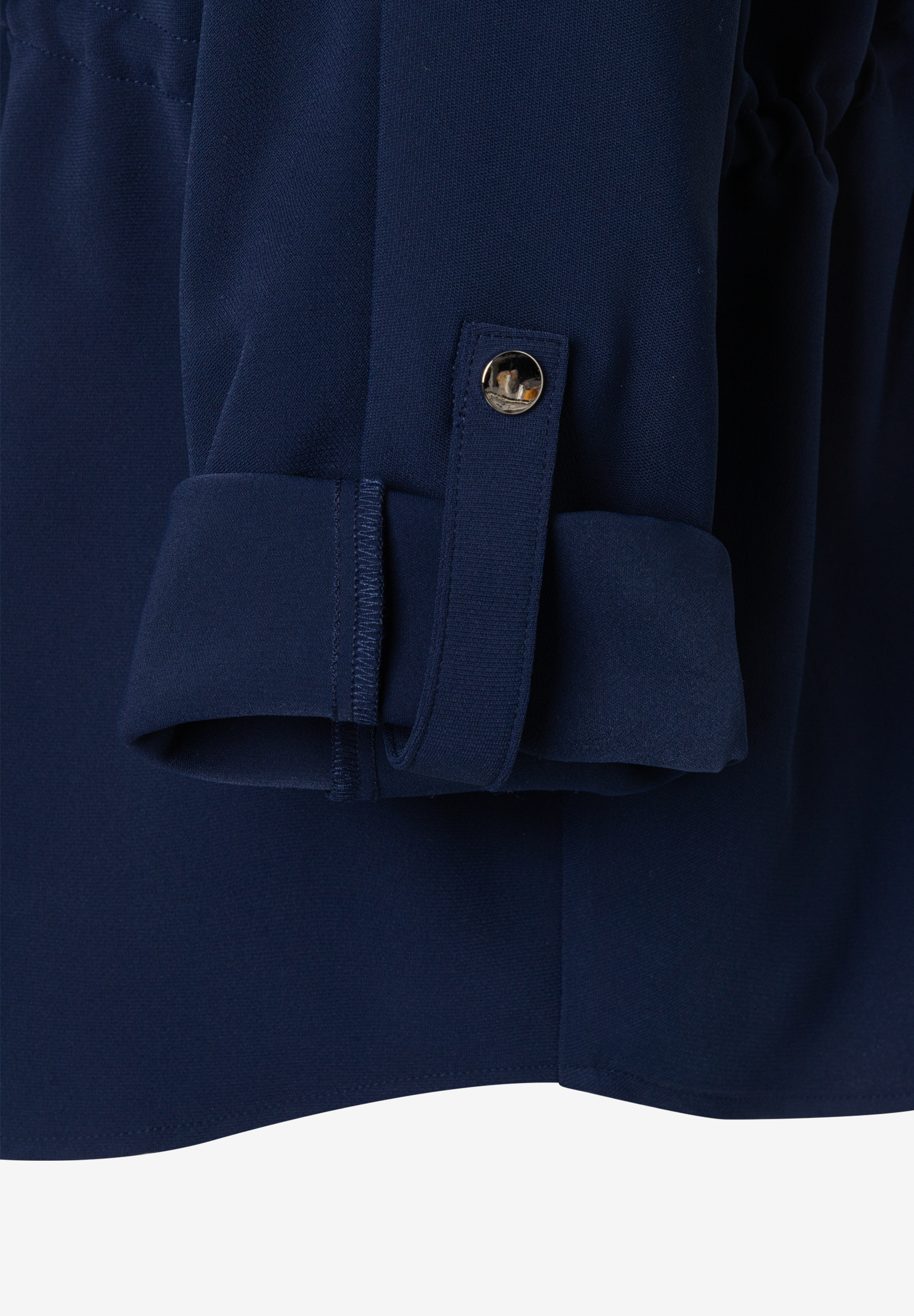 Nahaufnahme einer marineblauen MORE & MORE Bluse aus Webware mit Manschette und Knopfdetail. Nahaufnahme einer marineblauen MORE & MORE Bluse aus Webware mit Manschette und Knopfdetail.