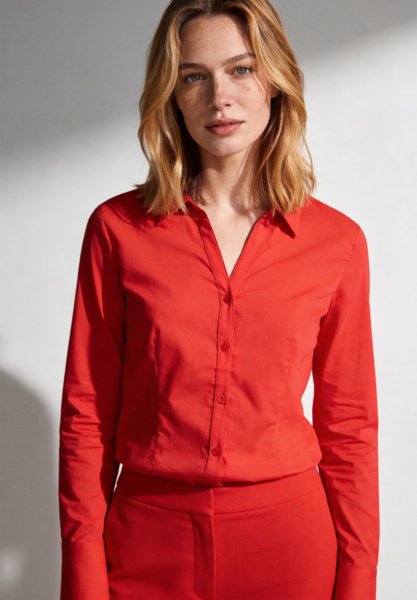 Eine Frau trägt eine rote Bluse von MORE & MORE aus Popeline mit langen Ärmeln. Eine Frau trägt eine rote Bluse von MORE & MORE aus Popeline mit langen Ärmeln.