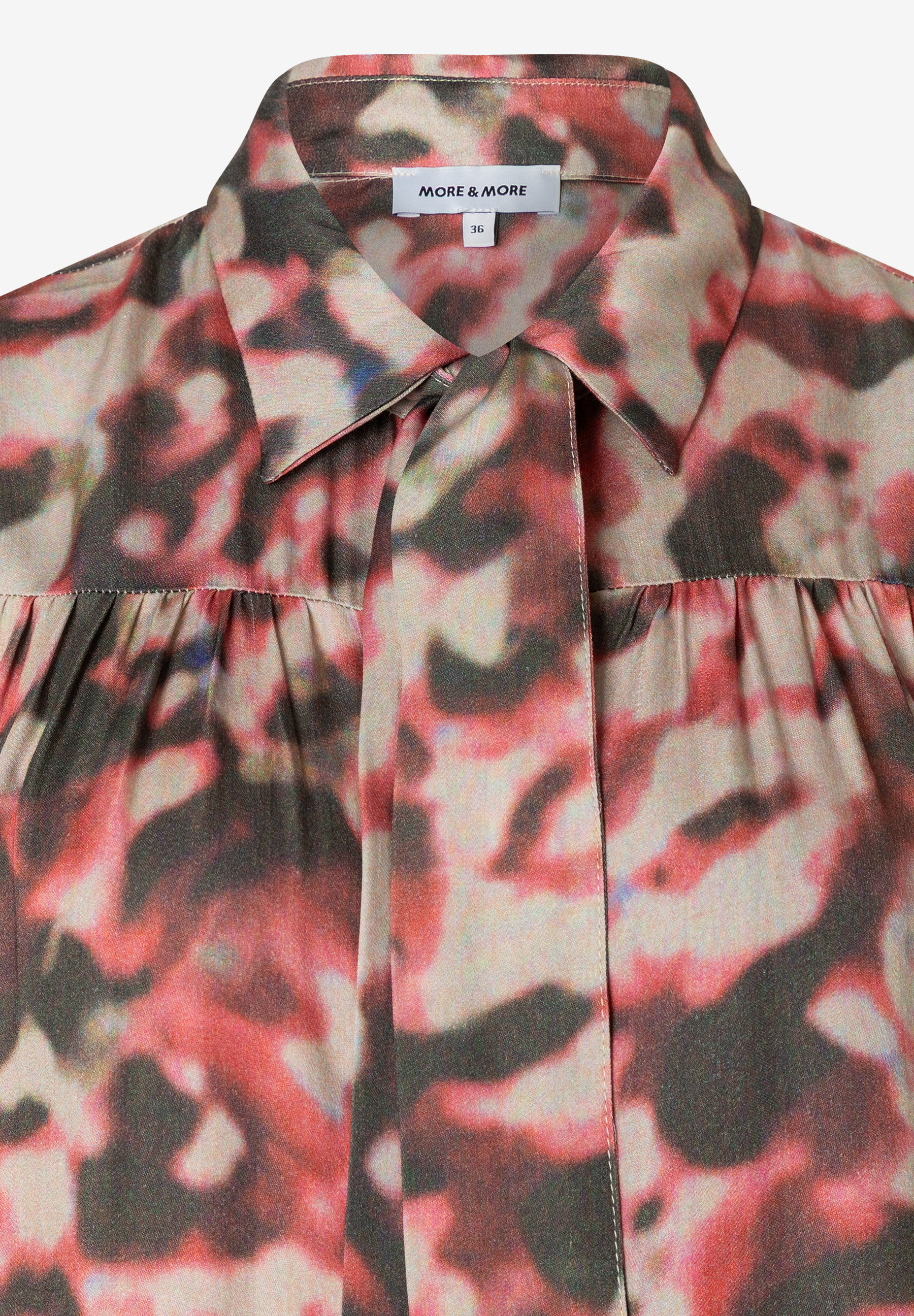 Nahaufnahme einer bedruckten MORE & MORE Bluse mit Kragen und Knopfleiste. Nahaufnahme einer bedruckten MORE & MORE Bluse mit Kragen und Knopfleiste.