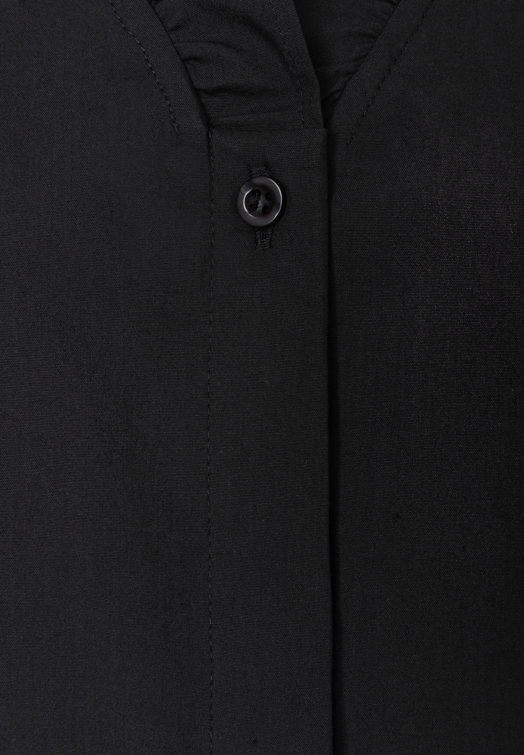 MORE & MORE Bluse, Nahaufnahme des schwarzen Knopfverschlusses, umgeben von geschmeidigem Stoff. MORE & MORE Bluse, Nahaufnahme des schwarzen Knopfverschlusses, umgeben von geschmeidigem Stoff.