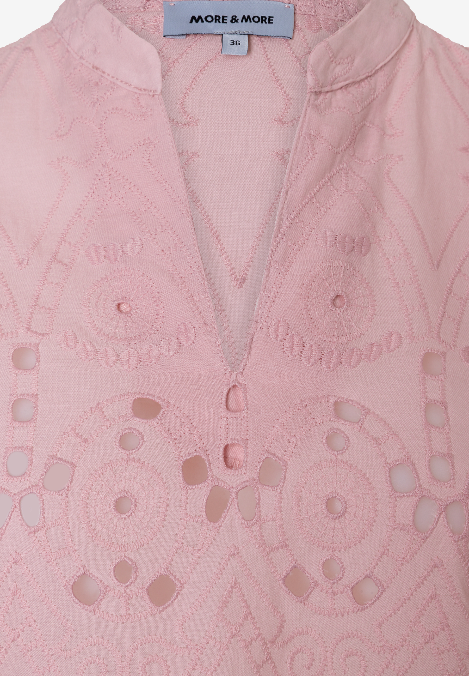 Nahaufnahme einer rosafarbenen MORE & MORE Bluse mit Lochstickerei.