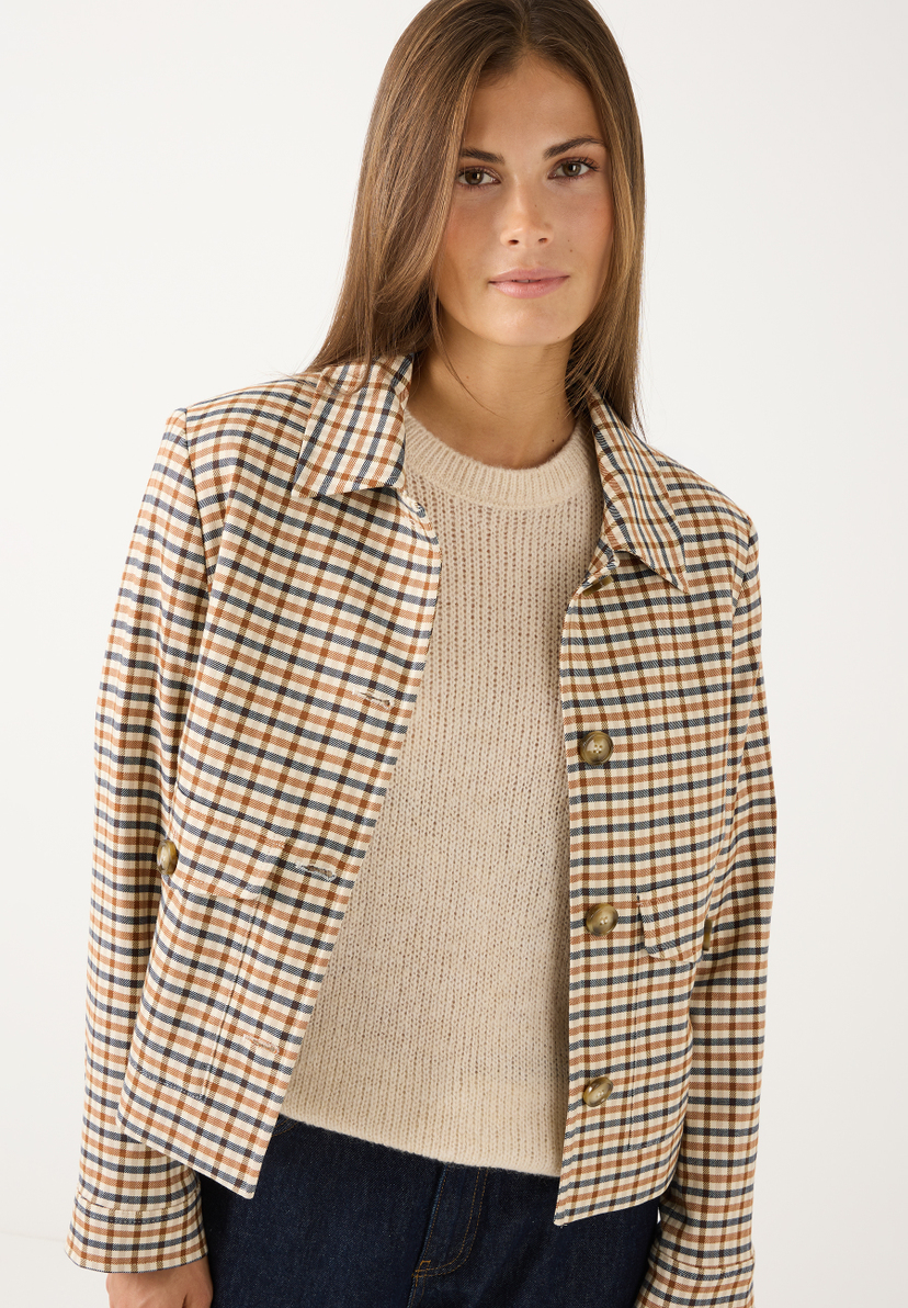 MORE & MORE Blazer: Eine Frau trägt einen karierten Blazer in Braun, Blau und Beige über einem beigefarbenen Strickpullover. MORE & MORE Blazer: Eine Frau trägt einen karierten Blazer in Braun, Blau und Beige über einem beigefarbenen Strickpullover.