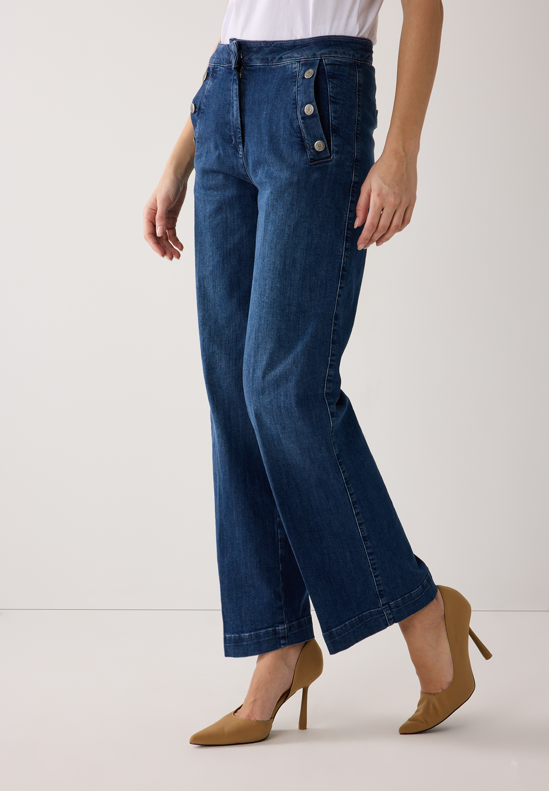 Eine Person trägt MORE & MORE Jeans aus Denim und braune High Heels. Eine Person trägt MORE & MORE Jeans aus Denim und braune High Heels.