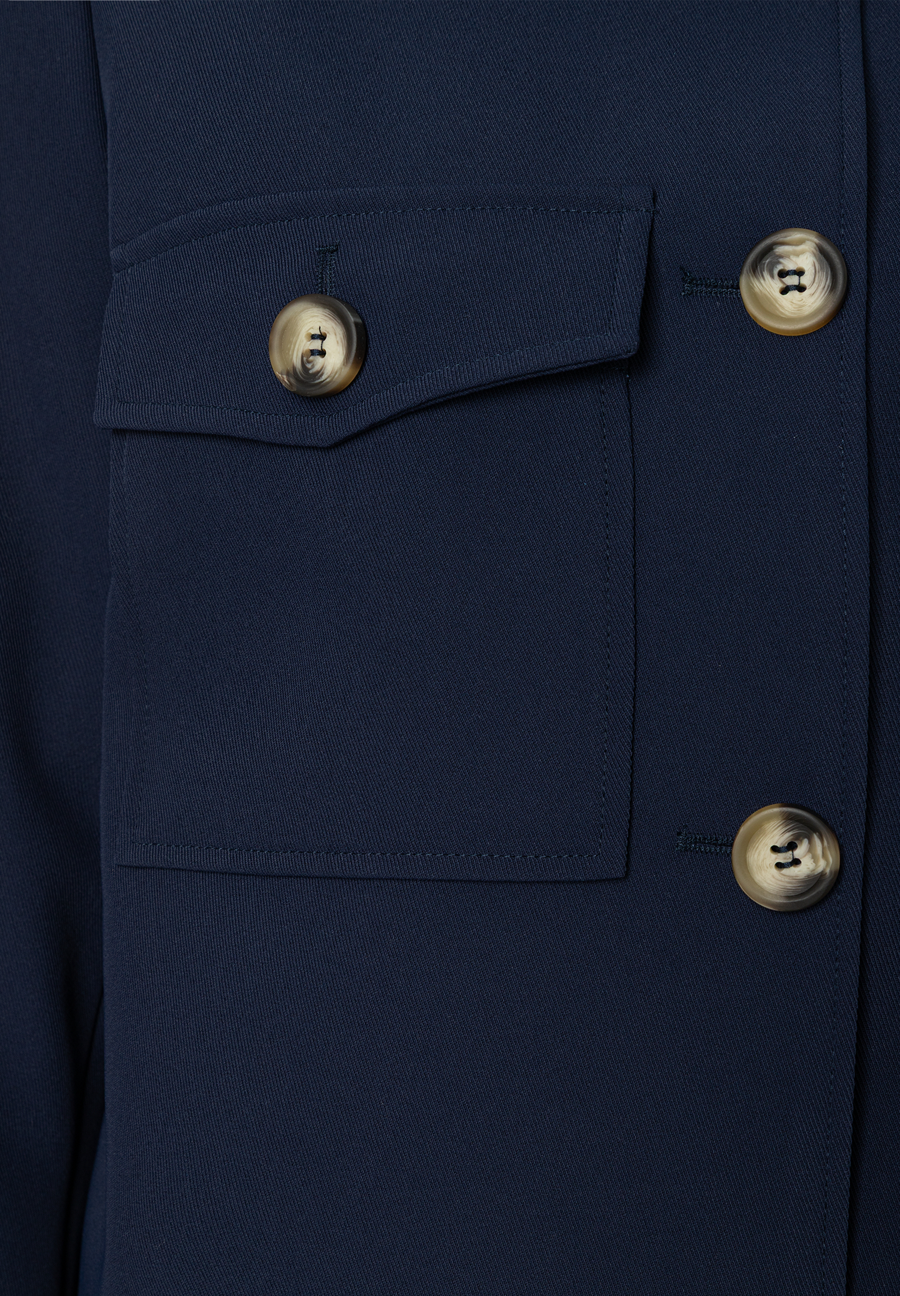 Nahaufnahme eines dunkelblauen MORE & MORE Blazers mit Hornknöpfen und aufgesetzter Brusttasche. Nahaufnahme eines dunkelblauen MORE & MORE Blazers mit Hornknöpfen und aufgesetzter Brusttasche.