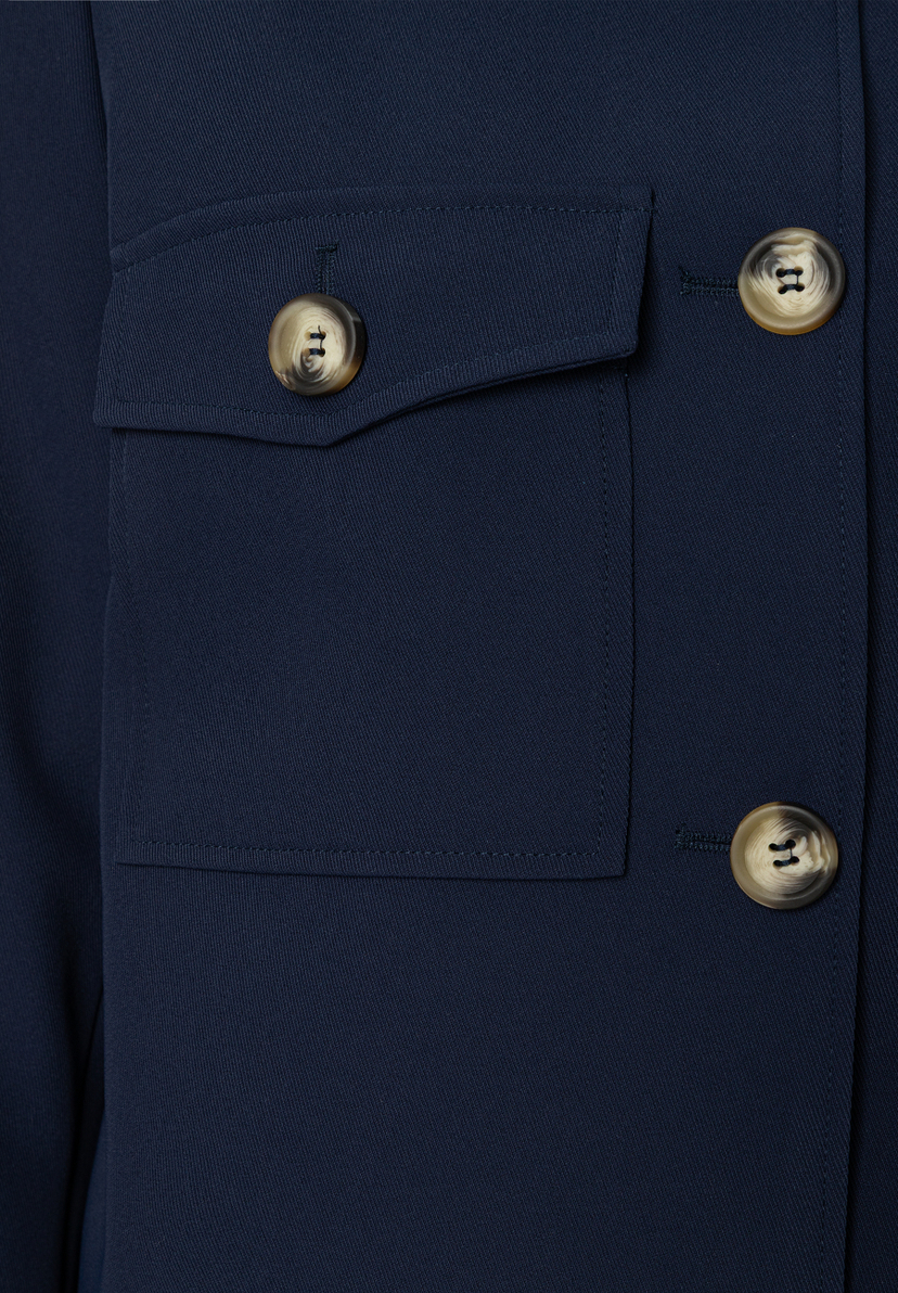 Nahaufnahme eines dunkelblauen MORE & MORE Blazers mit Hornknöpfen und aufgesetzter Brusttasche. Nahaufnahme eines dunkelblauen MORE & MORE Blazers mit Hornknöpfen und aufgesetzter Brusttasche.