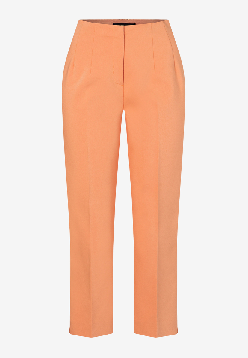 Eine orangefarbene Hose von MORE & MORE aus Baumwollmischung vor einem weißen Hintergrund. Eine orangefarbene Hose von MORE & MORE aus Baumwollmischung vor einem weißen Hintergrund.
