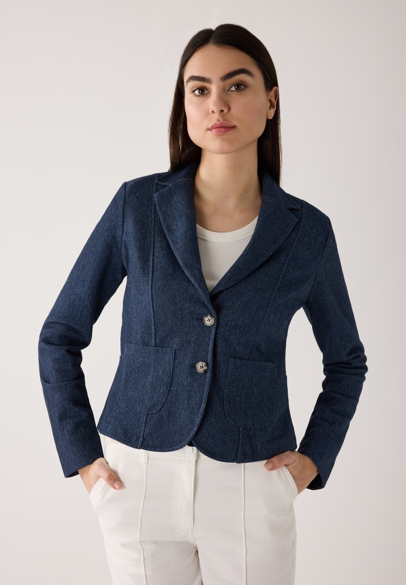 Eine Frau mit MORE & MORE Blazer und weißen Hosen posiert vor einem hellen Hintergrund. Eine Frau mit MORE & MORE Blazer und weißen Hosen posiert vor einem hellen Hintergrund.