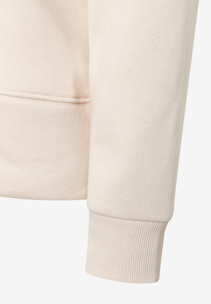 Detailaufnahme eines MORE & MORE Sweatshirts in Beige, Fokus auf Ärmel und Saum. Detailaufnahme eines MORE & MORE Sweatshirts in Beige, Fokus auf Ärmel und Saum.