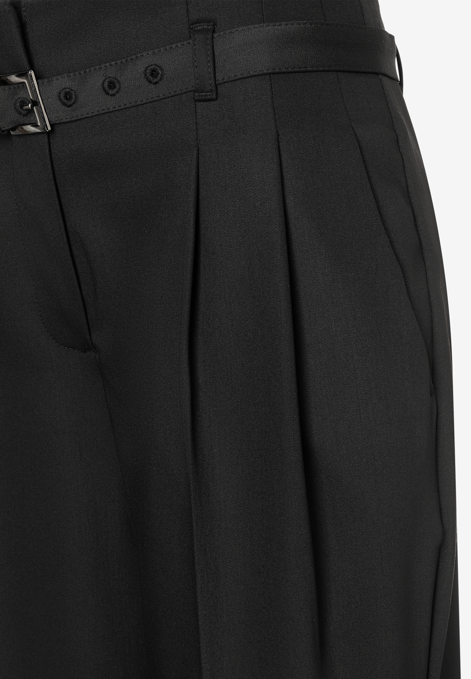 Nahaufnahme einer schwarzen MORE & MORE Hose mit Bundfalten und Gürtel. Nahaufnahme einer schwarzen MORE & MORE Hose mit Bundfalten und Gürtel.