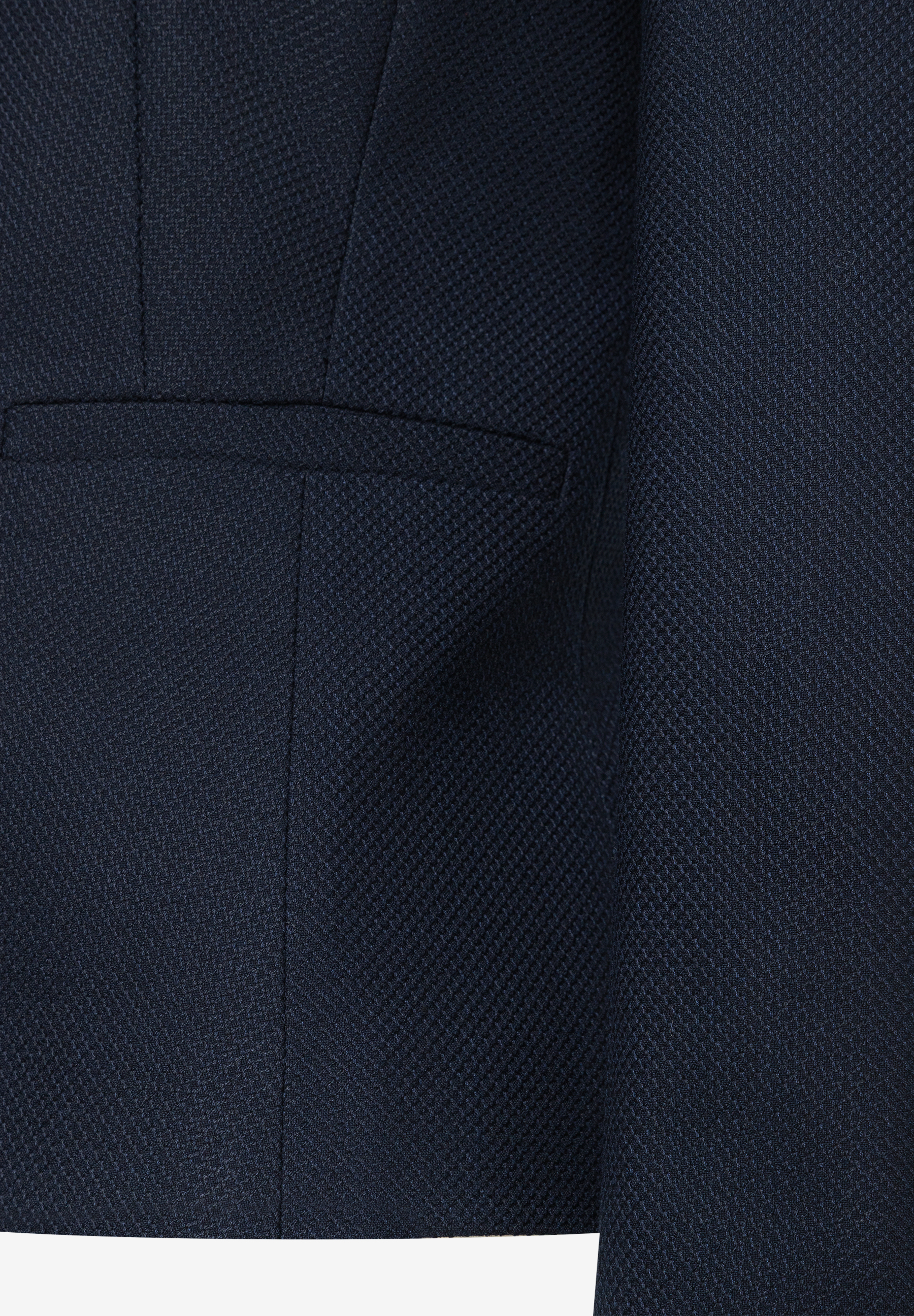 Detailaufnahme eines marineblauen MORE & MORE Blazers mit einer angedeuteten Tasche. Detailaufnahme eines marineblauen MORE & MORE Blazers mit einer angedeuteten Tasche.