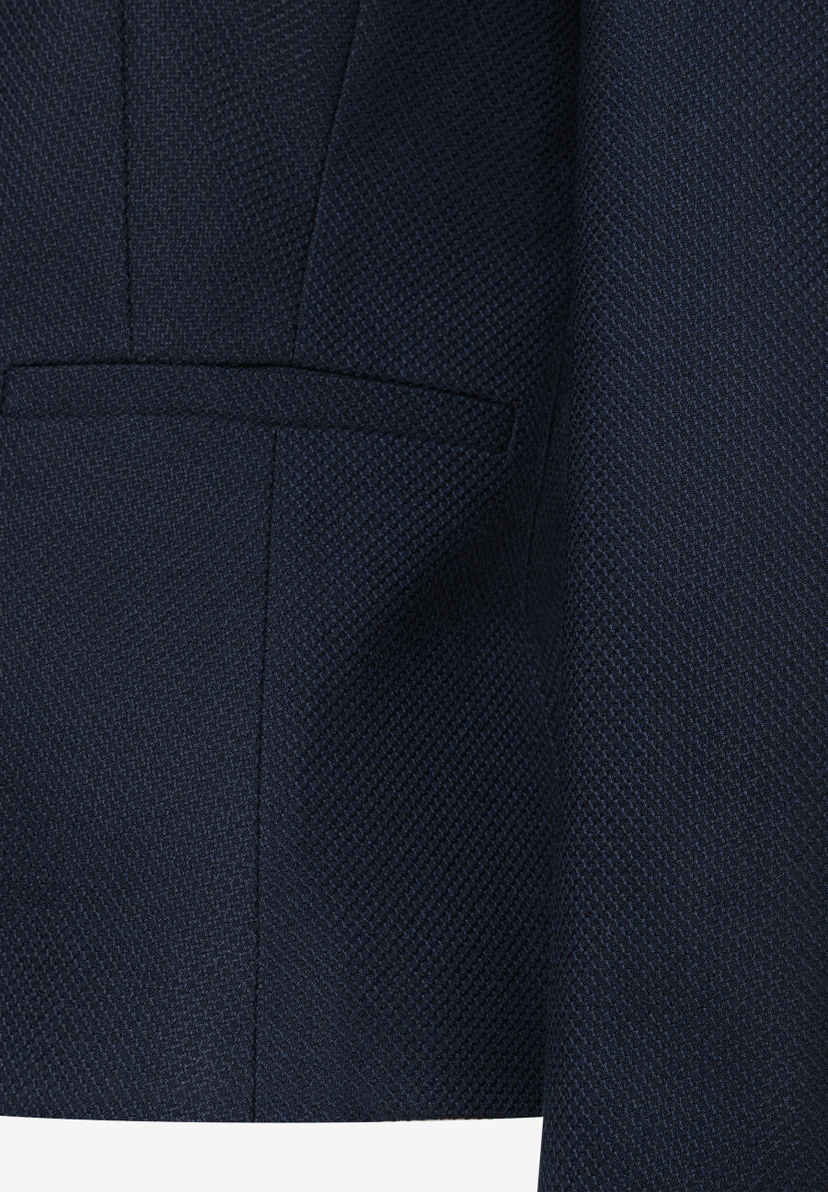 Detailaufnahme eines marineblauen MORE & MORE Blazers mit einer angedeuteten Tasche. Detailaufnahme eines marineblauen MORE & MORE Blazers mit einer angedeuteten Tasche.