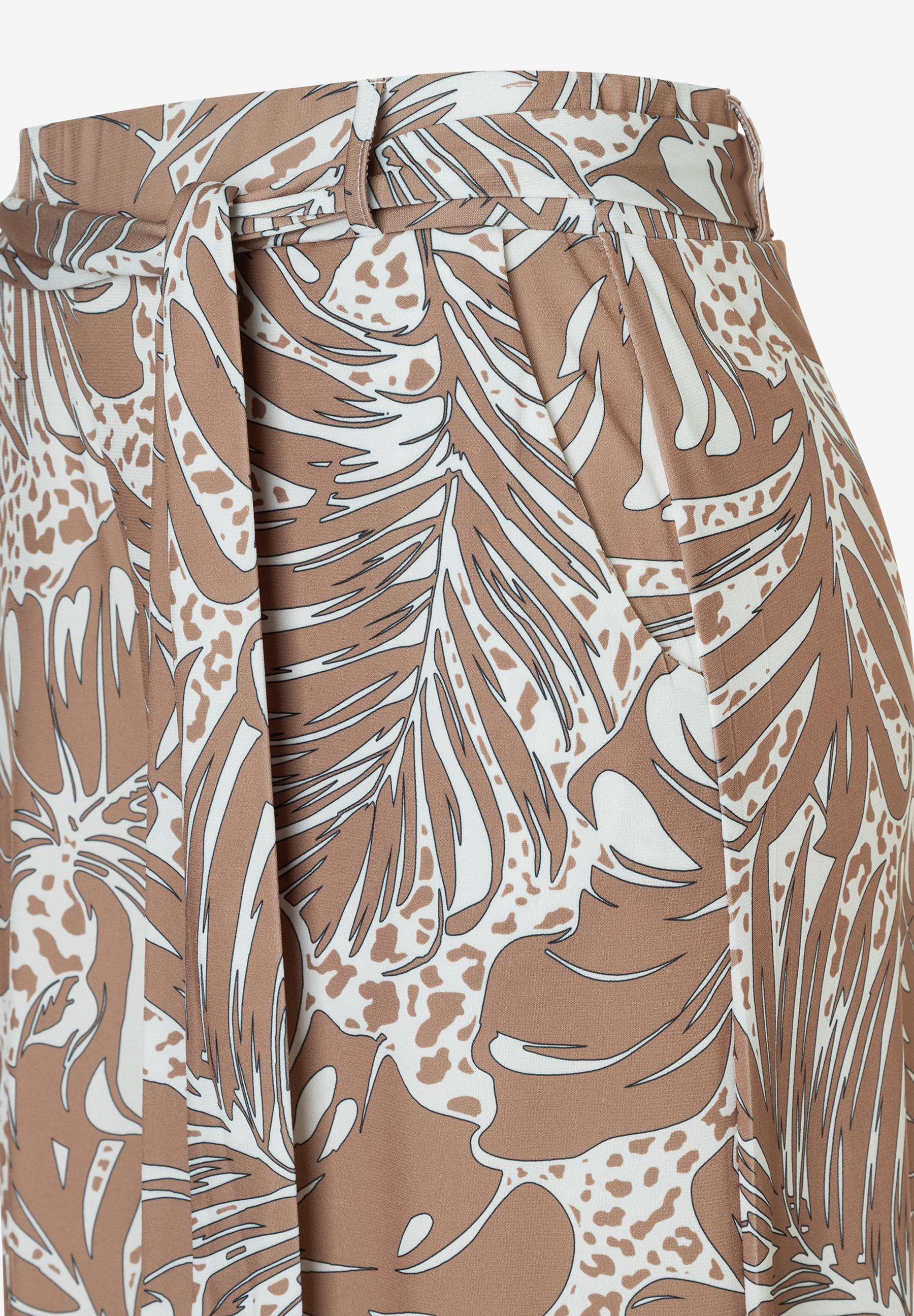 Nahaufnahme einer bedruckten MORE & MORE Jersey-Hose mit Bindeband. Das Muster ist braun, weiß mit Blättern und Flecken. Nahaufnahme einer bedruckten MORE & MORE Jersey-Hose mit Bindeband. Das Muster ist braun, weiß mit Blättern und Flecken.