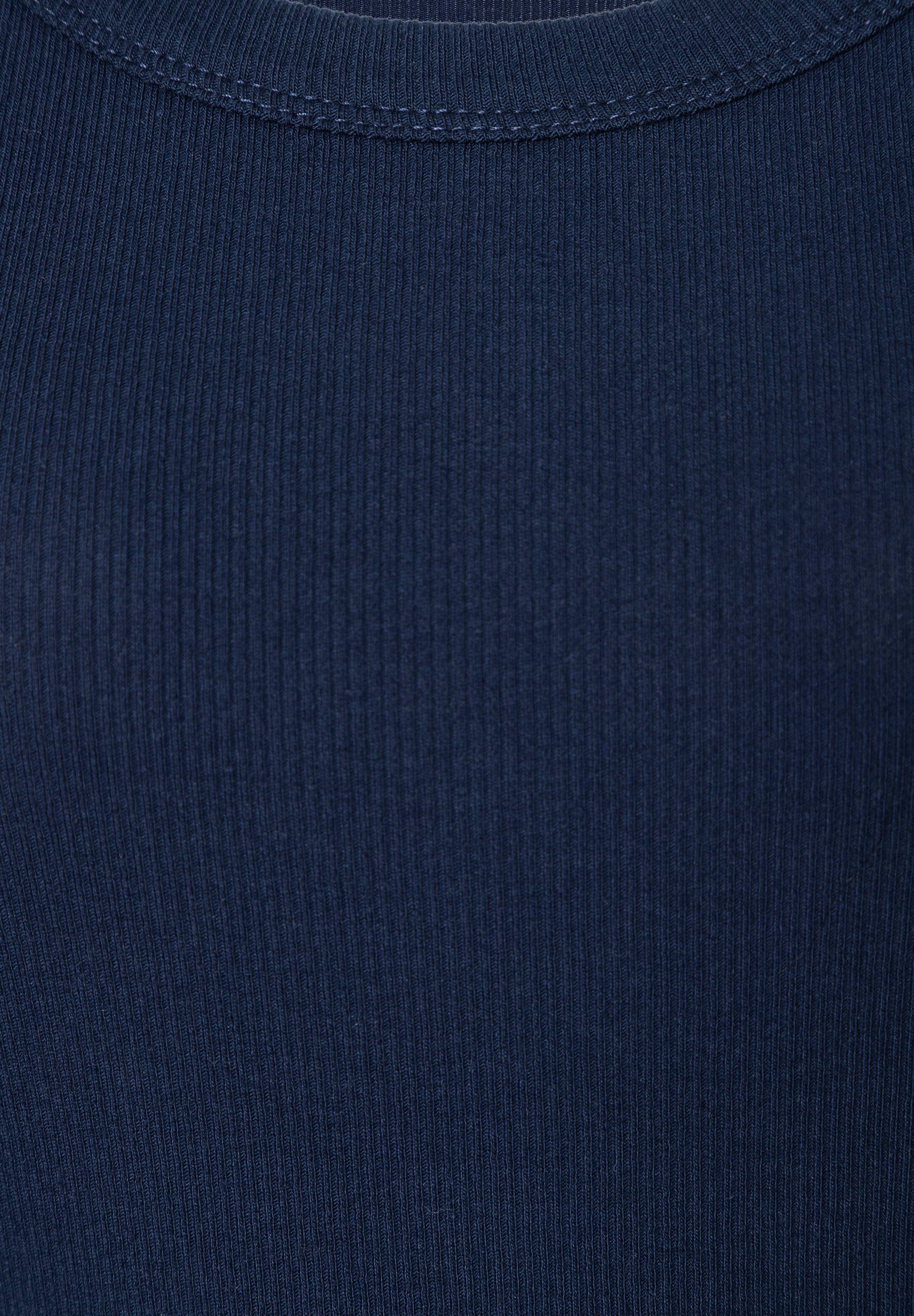 Nahaufnahme des gerippten Stoffes eines marineblauen MORE & MORE Oberteils. Nahaufnahme des gerippten Stoffes eines marineblauen MORE & MORE Oberteils.