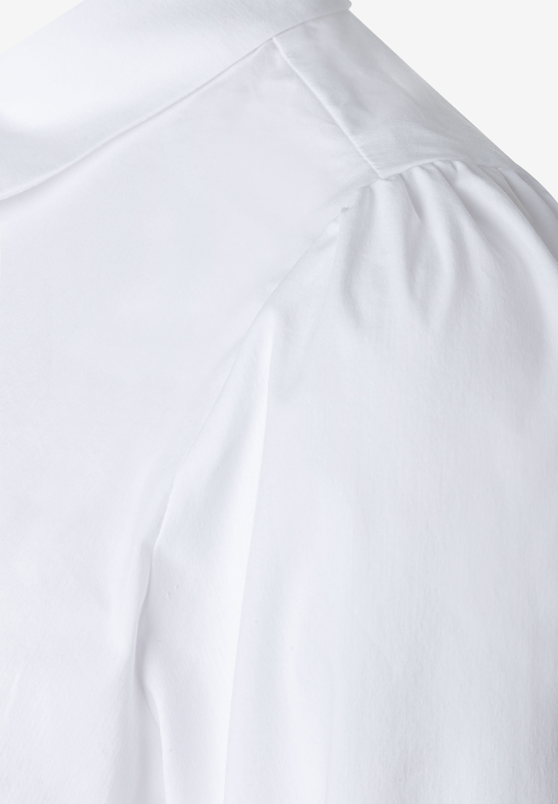 MORE & MORE Bluse: Eine Nahaufnahme des Oberteils einer weißen Bluse mit dezenten Falten an den Schultern.