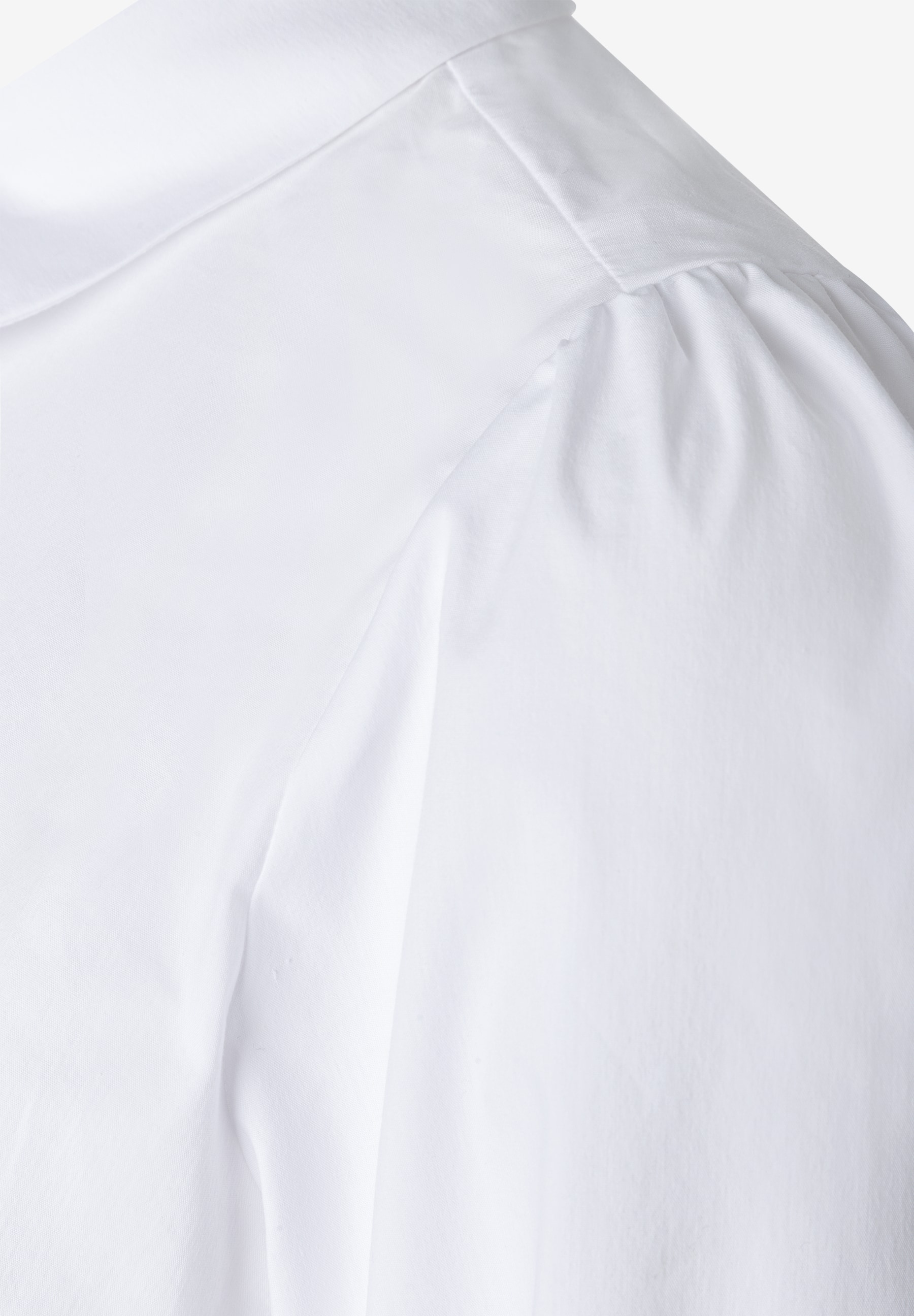 MORE & MORE Bluse: Eine Nahaufnahme des Oberteils einer weißen Bluse mit dezenten Falten an den Schultern. MORE & MORE Bluse: Eine Nahaufnahme des Oberteils einer weißen Bluse mit dezenten Falten an den Schultern.