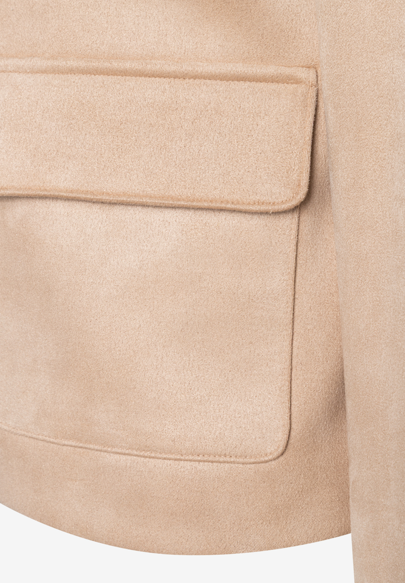 Nahaufnahme einer beigen MORE & MORE Jacke mit Tasche aus Kunstleder. Nahaufnahme einer beigen MORE & MORE Jacke mit Tasche aus Kunstleder.