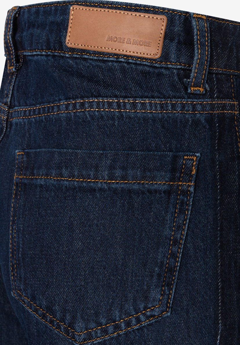 MORE & MORE Jeans: Nahaufnahme der dunkelblauen Hose, mit braunem Markenetikett und orangefarbenen Nähten an den Gesäßtaschen.