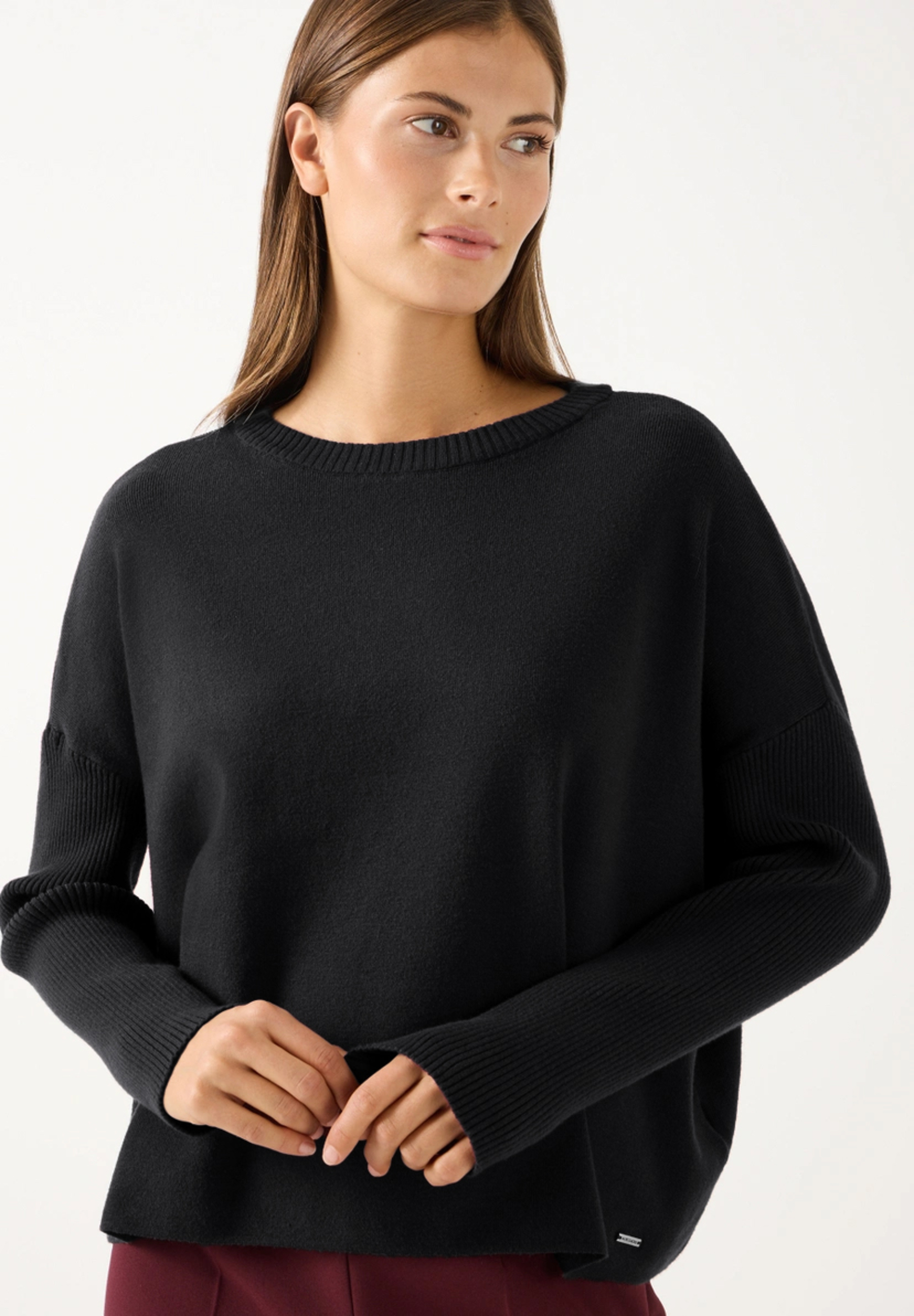 MORE & MORE Feinstrick-Pullover in Burgunderrot, lockere Passform, elastisch & hautfreundlich. Eine junge Frau trägt das Oberteil.