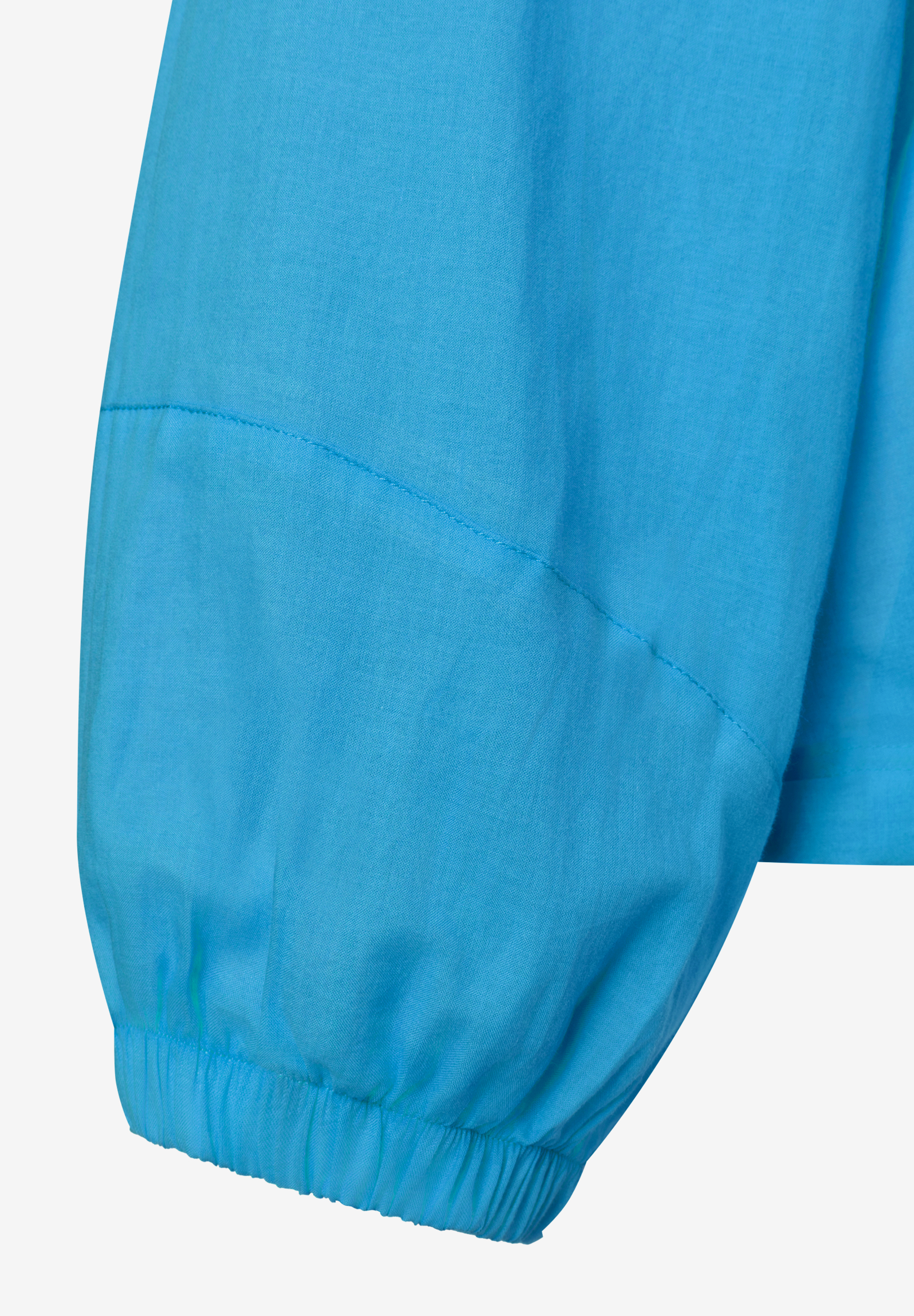 MORE & MORE Bluse: Detailansicht des Ärmels aus blauer, leichter Baumwoll-Webware mit Bündchen. MORE & MORE Bluse: Detailansicht des Ärmels aus blauer, leichter Baumwoll-Webware mit Bündchen.