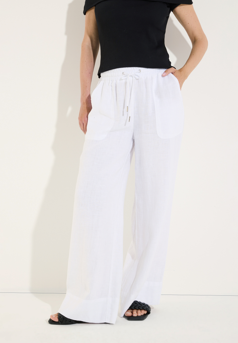 MORE & MORE Leinenhose, weiß, mit weitem Bein, Kordelzug und 2 Taschen, getragen mit schwarzem Off-Shoulder-Top und schwarzen Sandalen. MORE & MORE Leinenhose, weiß, mit weitem Bein, Kordelzug und 2 Taschen, getragen mit schwarzem Off-Shoulder-Top und schwarzen Sandalen.