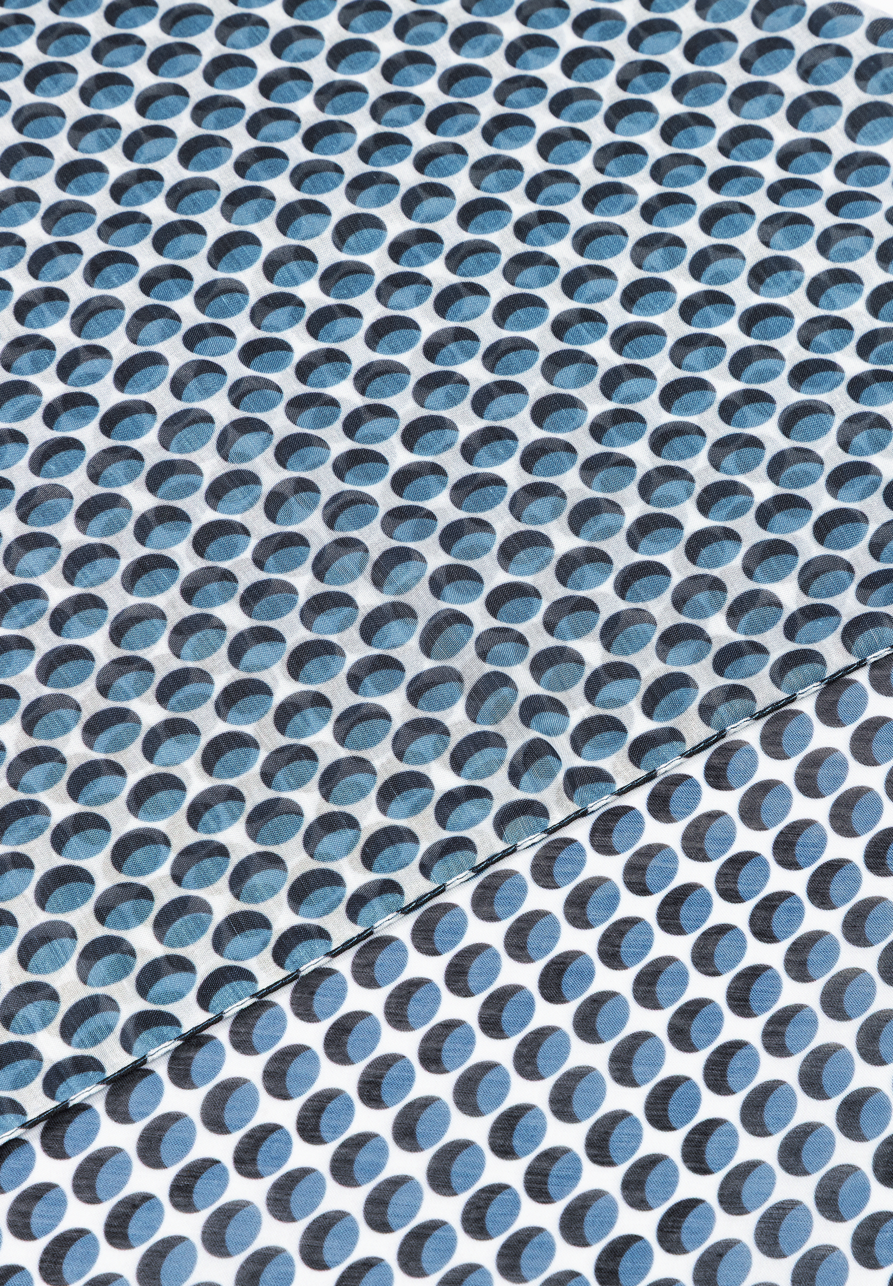 Ein MORE & MORE Accessoire mit blau-schwarzem Punktmuster auf weißem Grund, diagonal geteilt. Ein MORE & MORE Accessoire mit blau-schwarzem Punktmuster auf weißem Grund, diagonal geteilt.