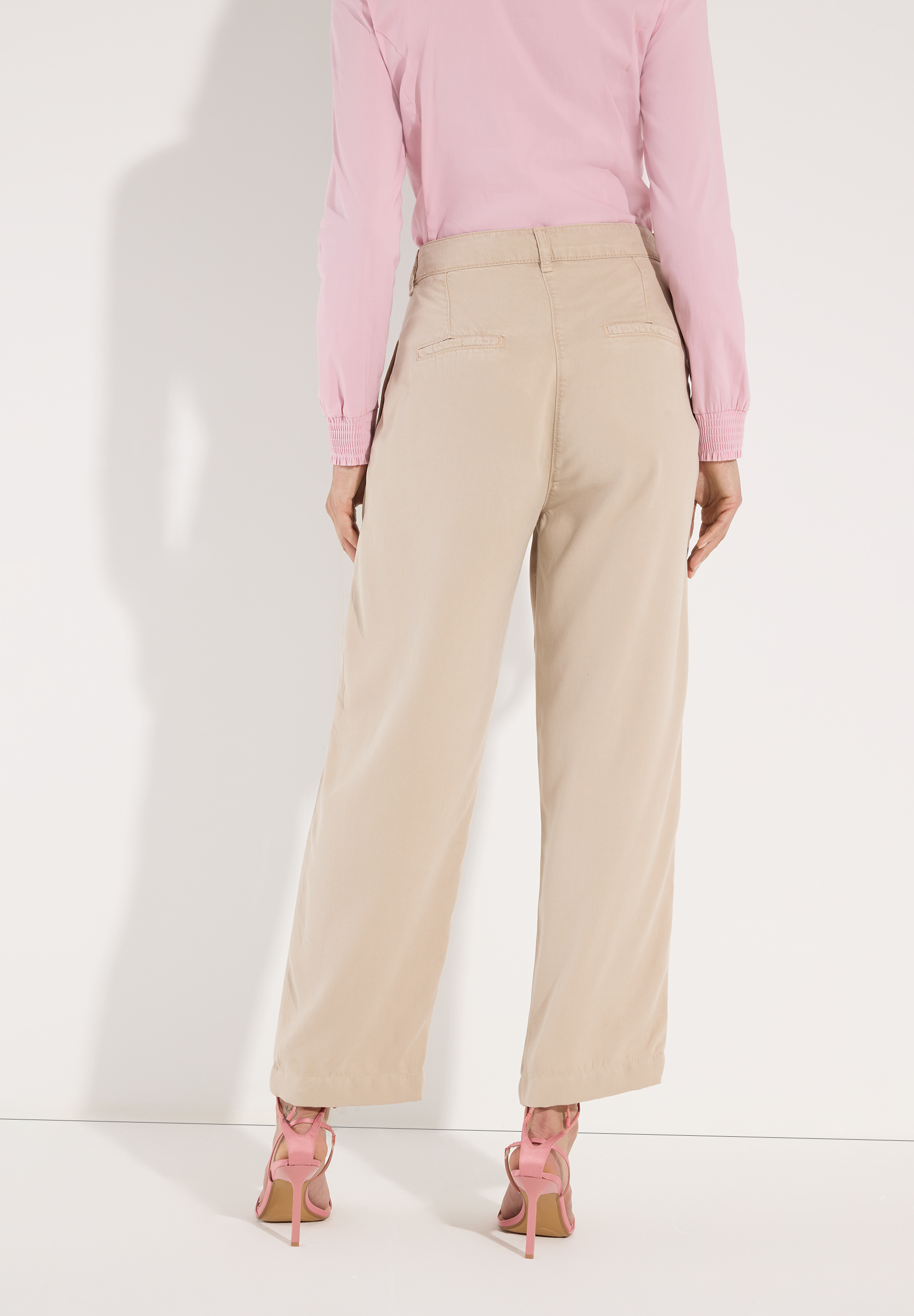 MORE & MORE Jeans aus Webware in Beige und rosafarbenen Absatzschuhen, Rückansicht. MORE & MORE Jeans aus Webware in Beige und rosafarbenen Absatzschuhen, Rückansicht.