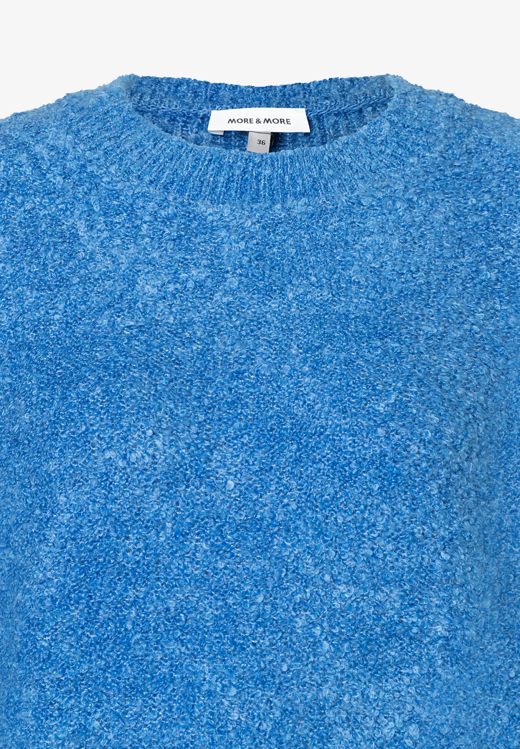 Nahaufnahme eines blauen MORE & MORE Bouclé-Pullovers, warmer Strick für angenehmen Tragekomfort. Nahaufnahme eines blauen MORE & MORE Bouclé-Pullovers, warmer Strick für angenehmen Tragekomfort.