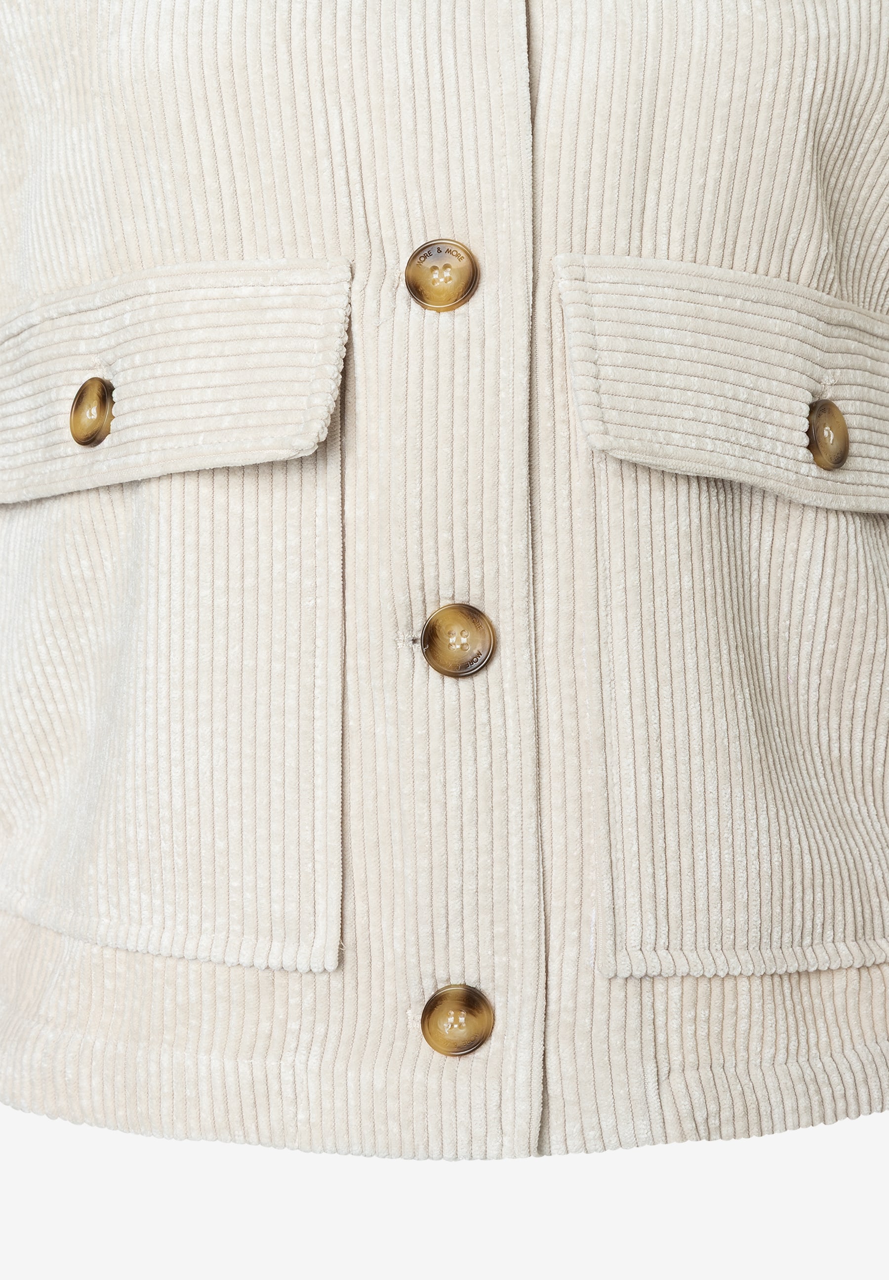 Nahaufnahme einer hellen Cordjacke von MORE & MORE mit Taschen und Knöpfen. Nahaufnahme einer hellen Cordjacke von MORE & MORE mit Taschen und Knöpfen.
