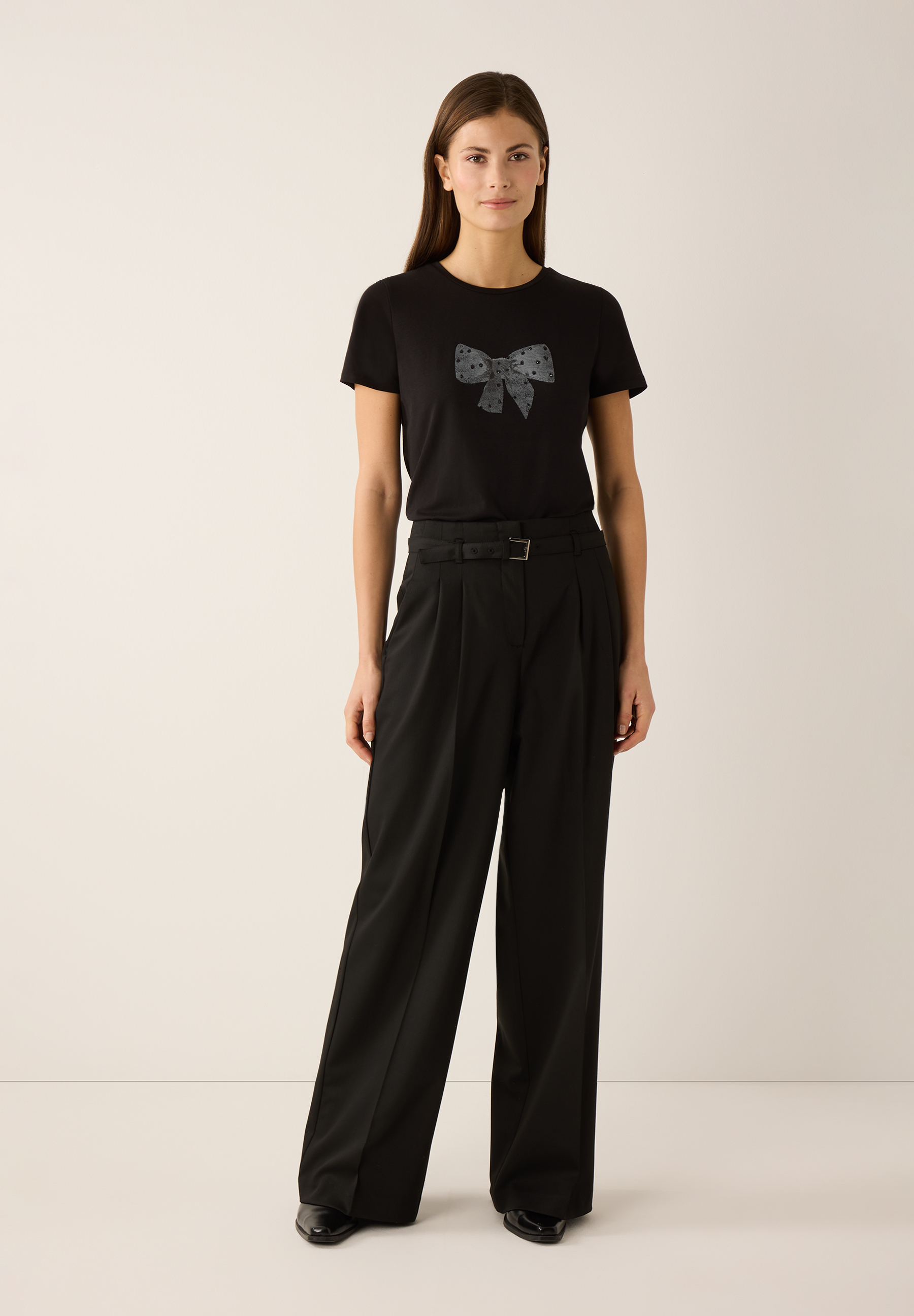 Eine Person, die MORE & MORE Webware-Hosen und schwarze Schuhe trägt. Eine Person, die MORE & MORE Webware-Hosen und schwarze Schuhe trägt.