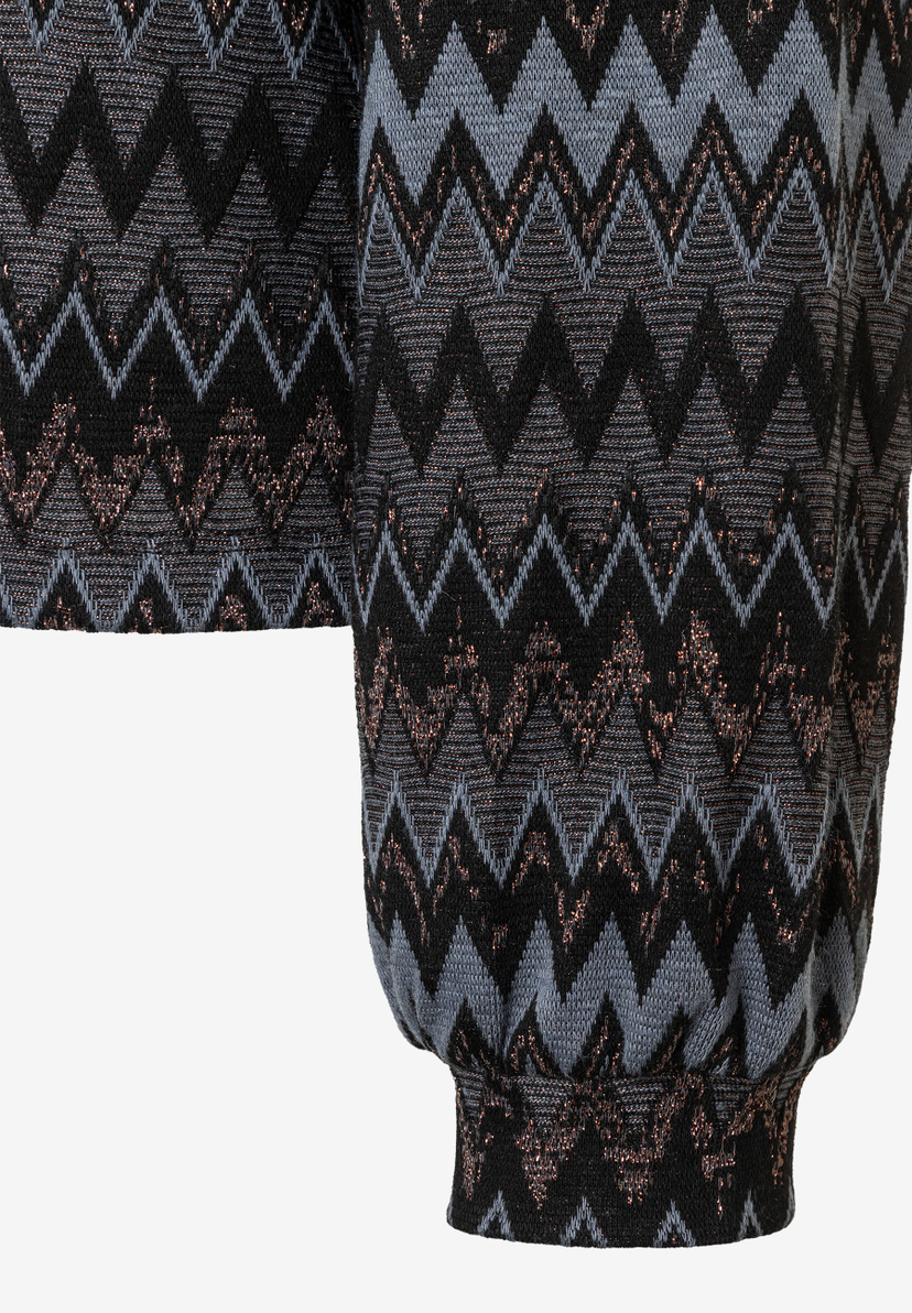 Detailaufnahme eines MORE & MORE Oberteils mit Zickzackmuster und elastischem Jersey. Detailaufnahme eines MORE & MORE Oberteils mit Zickzackmuster und elastischem Jersey.